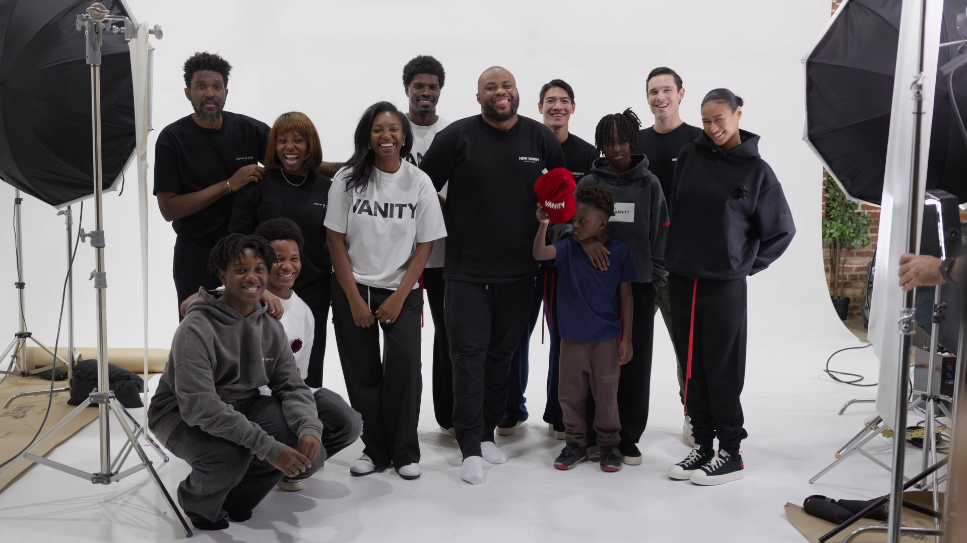 Group photo of the production team and models during a brand identity photoshoot in a professional studio setting.