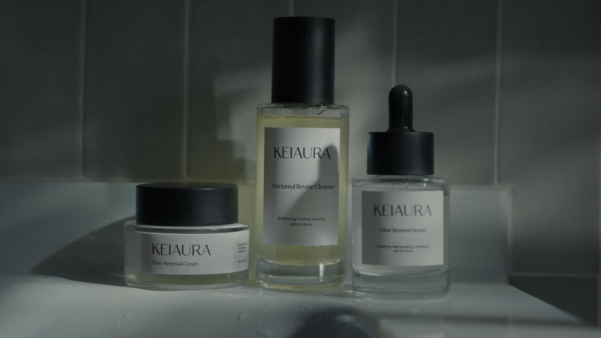 A complete Keiaura skincare line, including Nocturnal Revive Cleanser, Glow Renewal Cream, and Glow Renewal Serum, displayed in a minimalist bathroom. Highlighting the premium branding and visual storytelling delivered by Surkov Film.