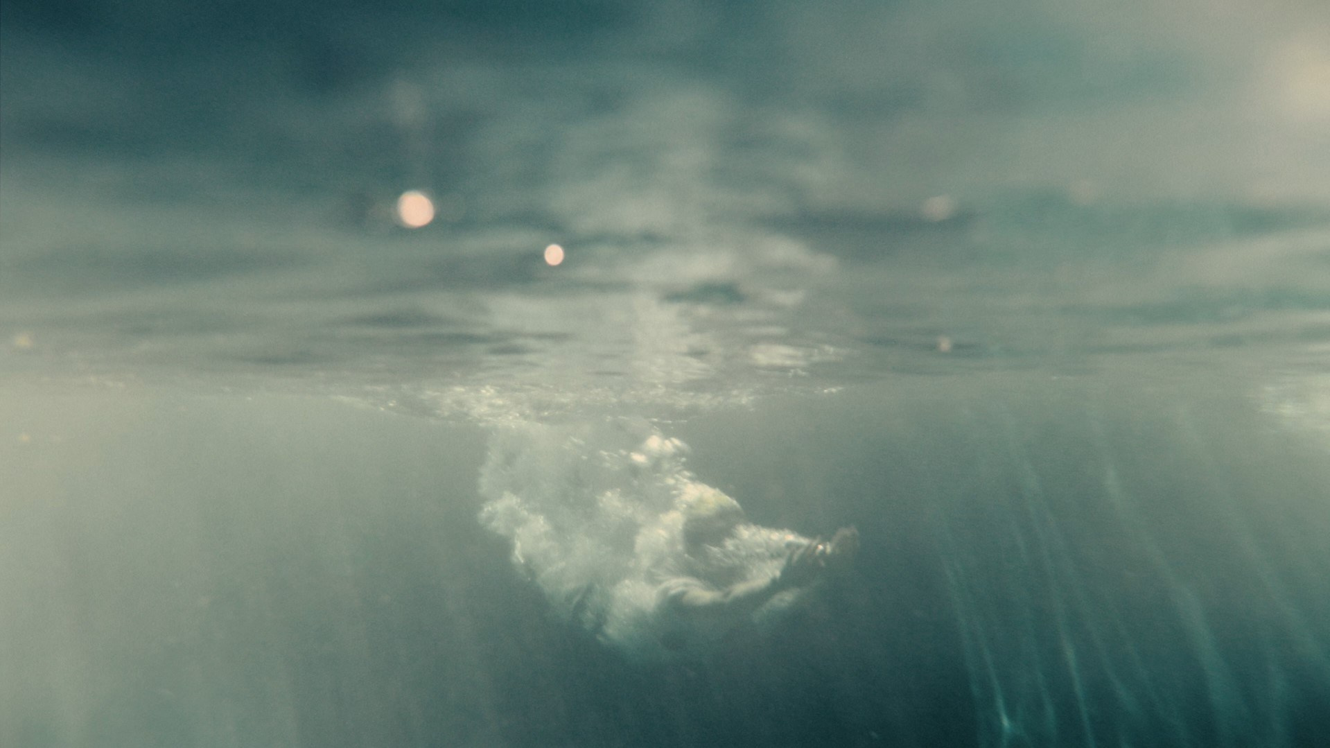Underwater shot with sun rays breaking through, creating a serene and ethereal mood.