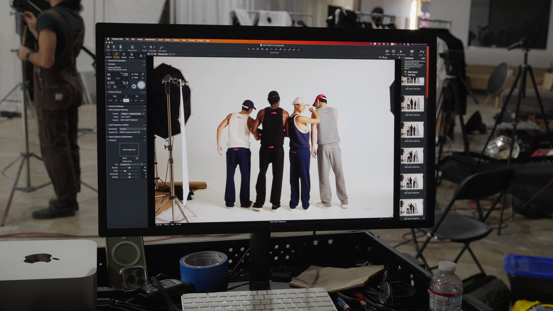 Behind-the-scenes view of a brand identity photoshoot displayed on a monitor, featuring diverse models in a professional studio.