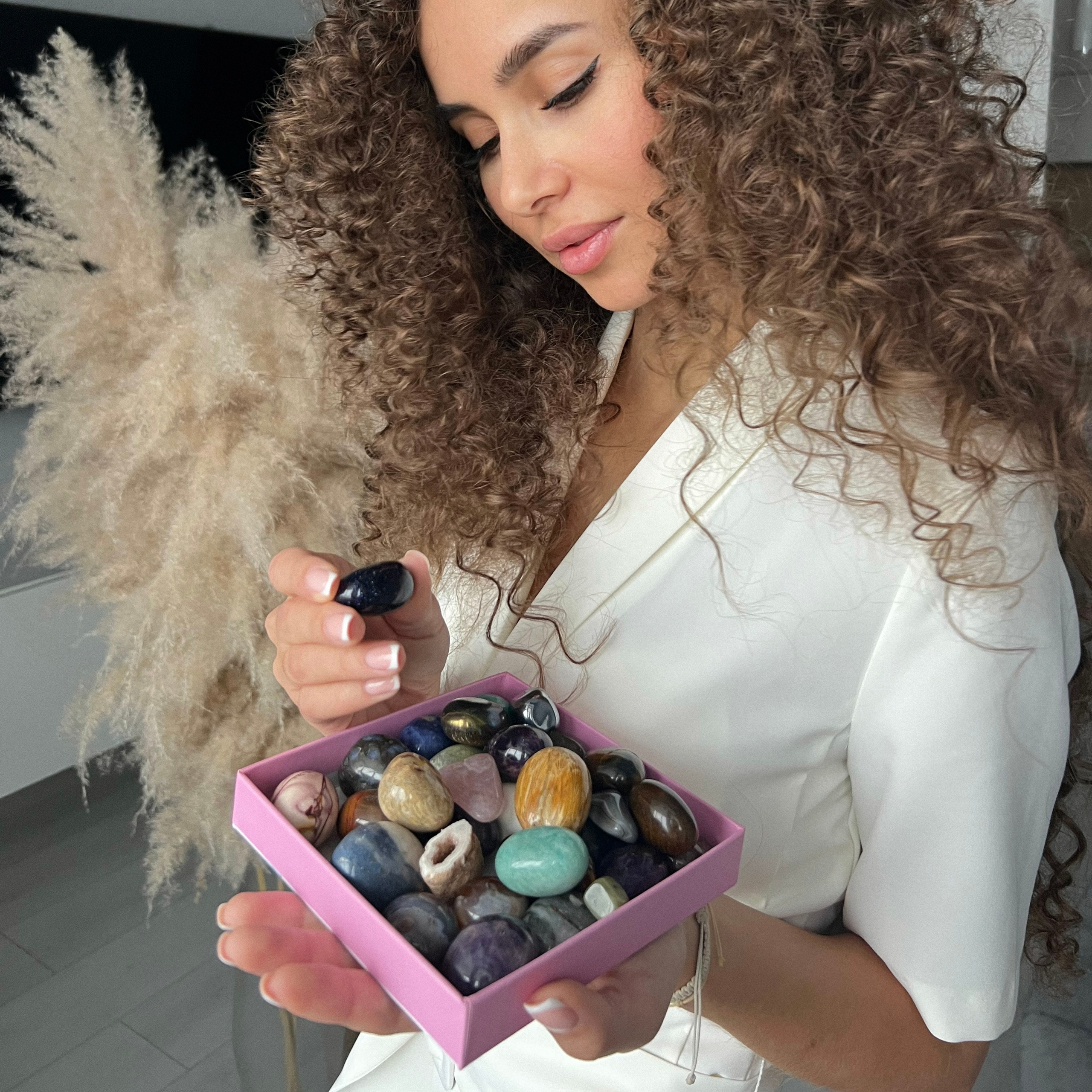 Девушка выбирает минералы из коллекции они все разнообразны и красивы