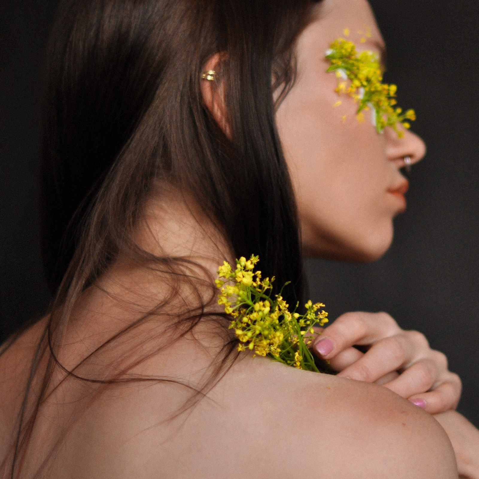 Лицо и плечо женщины украшенное жёлтыми цветами, подчёркивает художественную эстетику, вдохновлённую цветами