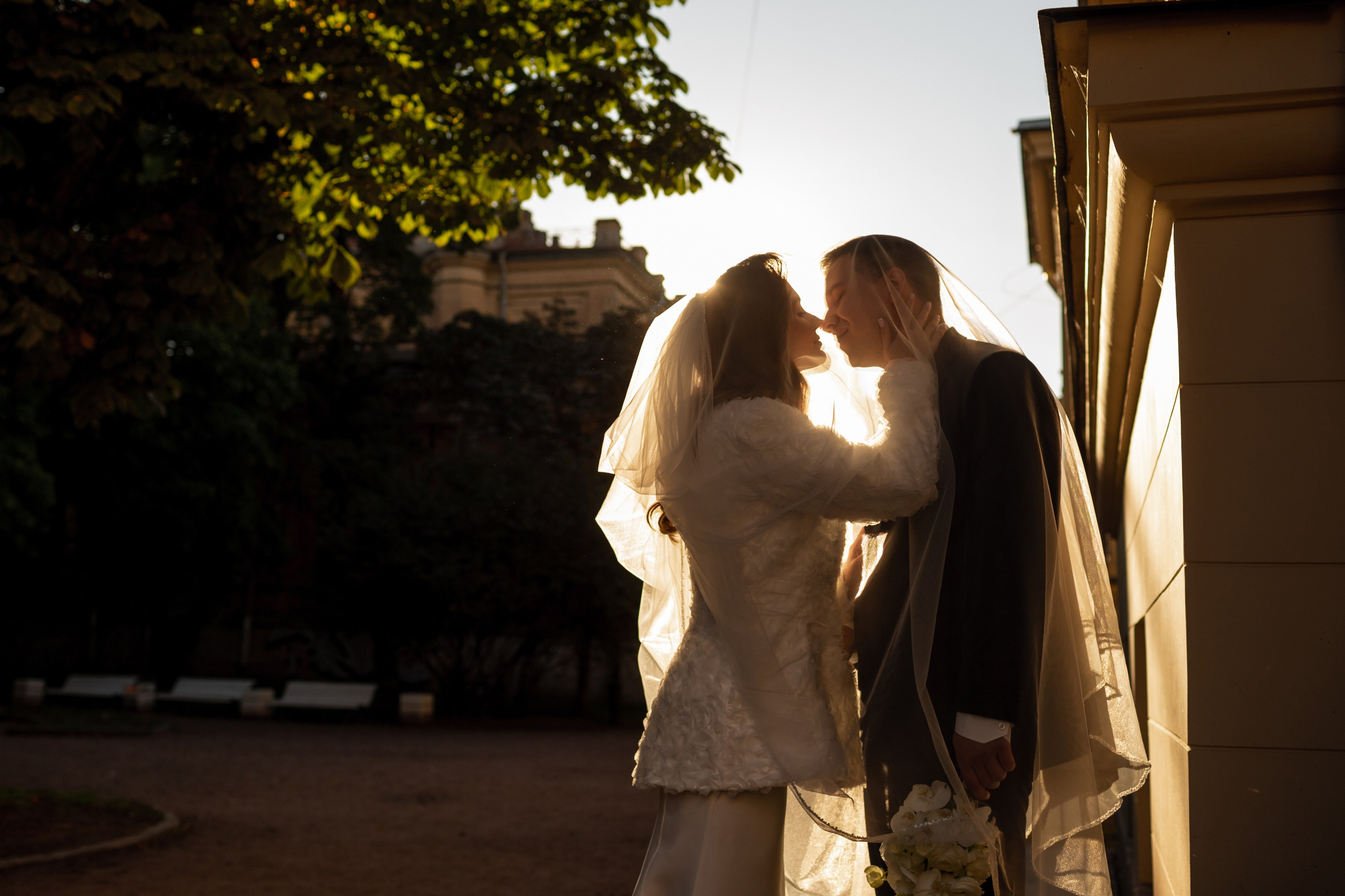 Свадебная фотопрогулка в поле: жених и невеста целуются в люпинах.