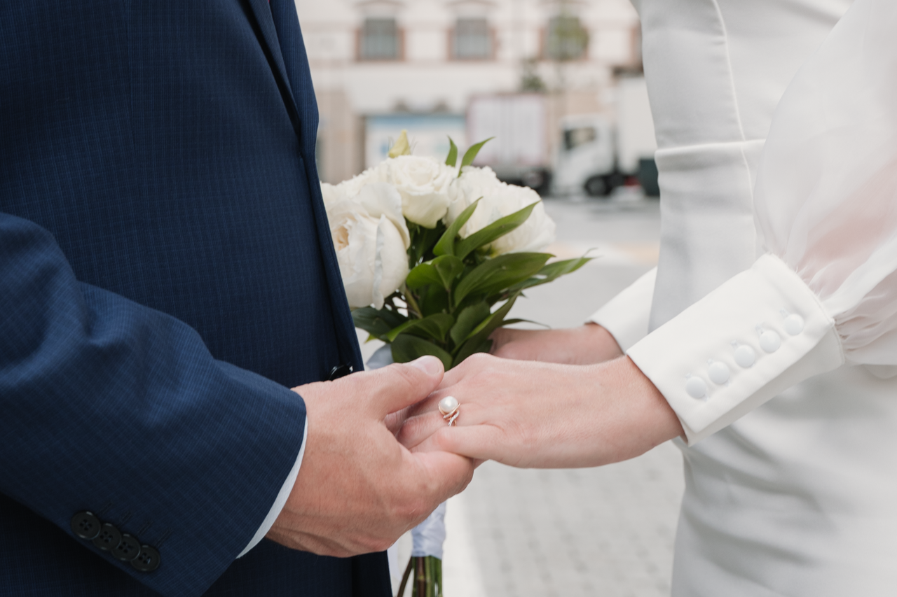 Фотография молодожен  державших за руки 