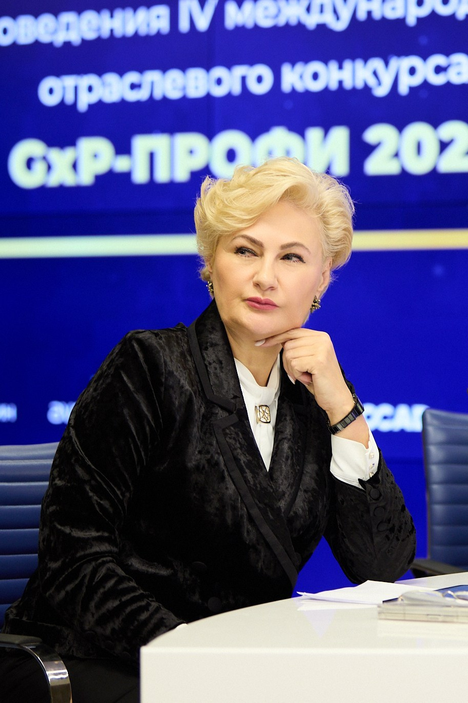 Бизнес-репортаж: портрет Спичак И.В. на фоне информационного экрана отраслевого конкурса. Пример событийной фотосъемки.