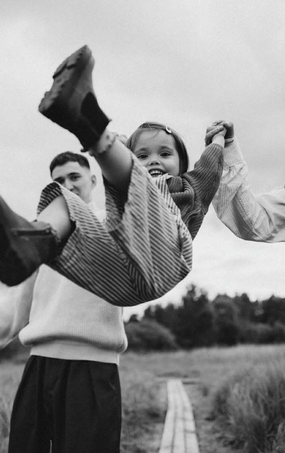 мама и папа поднимают за руки малыша радость