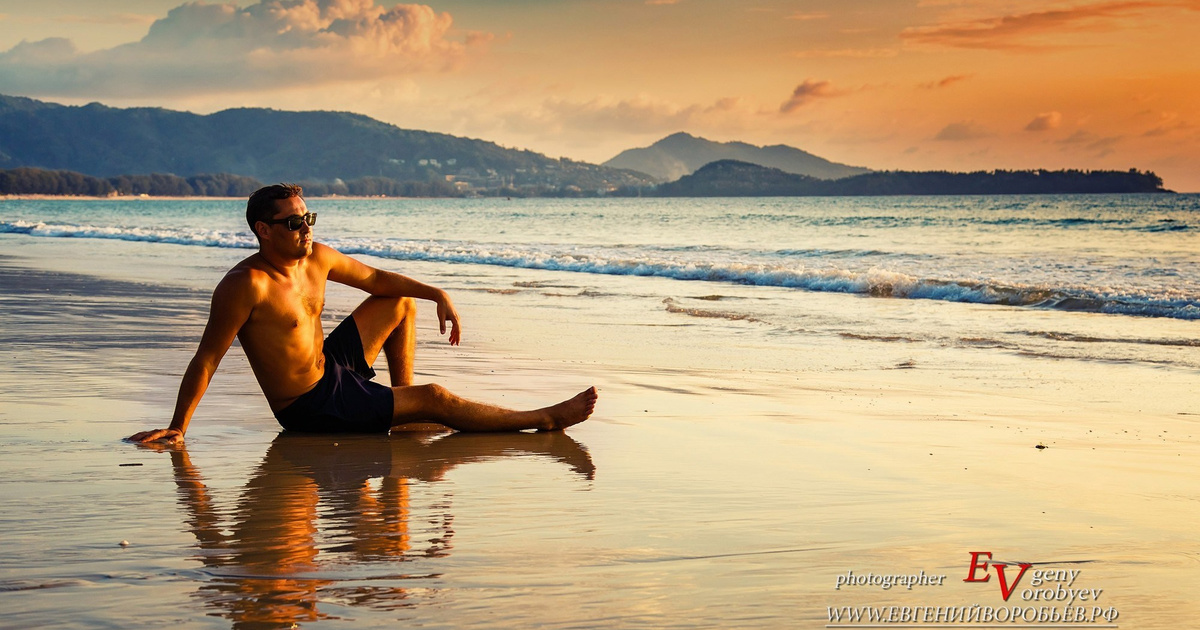 мужчина в позе воина на фоне океана