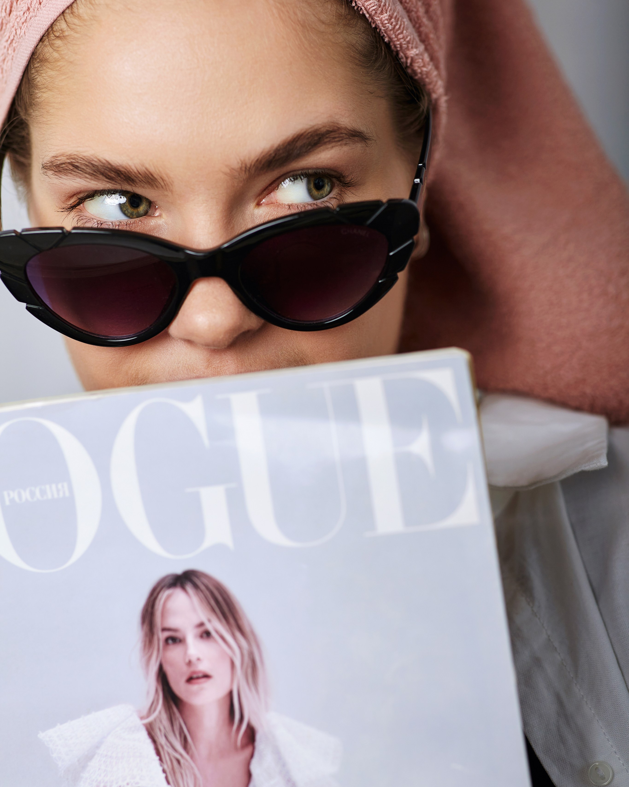 Молодая модель в фотостудии в Москве, готовясь к портретной съемке в яркой одежде.