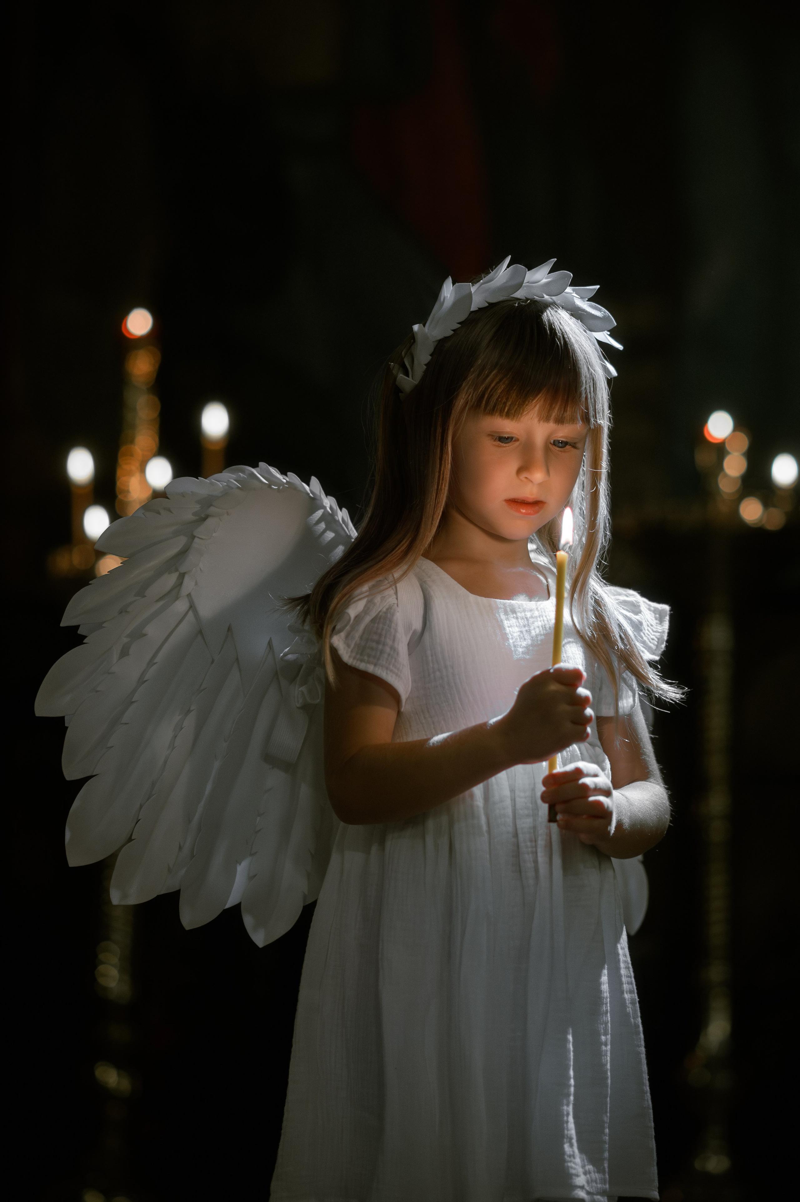 Девочка в храме со свечой в белом платье 