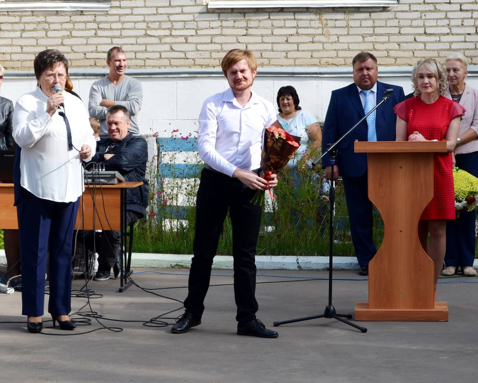 Кирилл Ситнов получает букет на торжественной линейке 1 сентября в МОУ Рыболовская СОШ