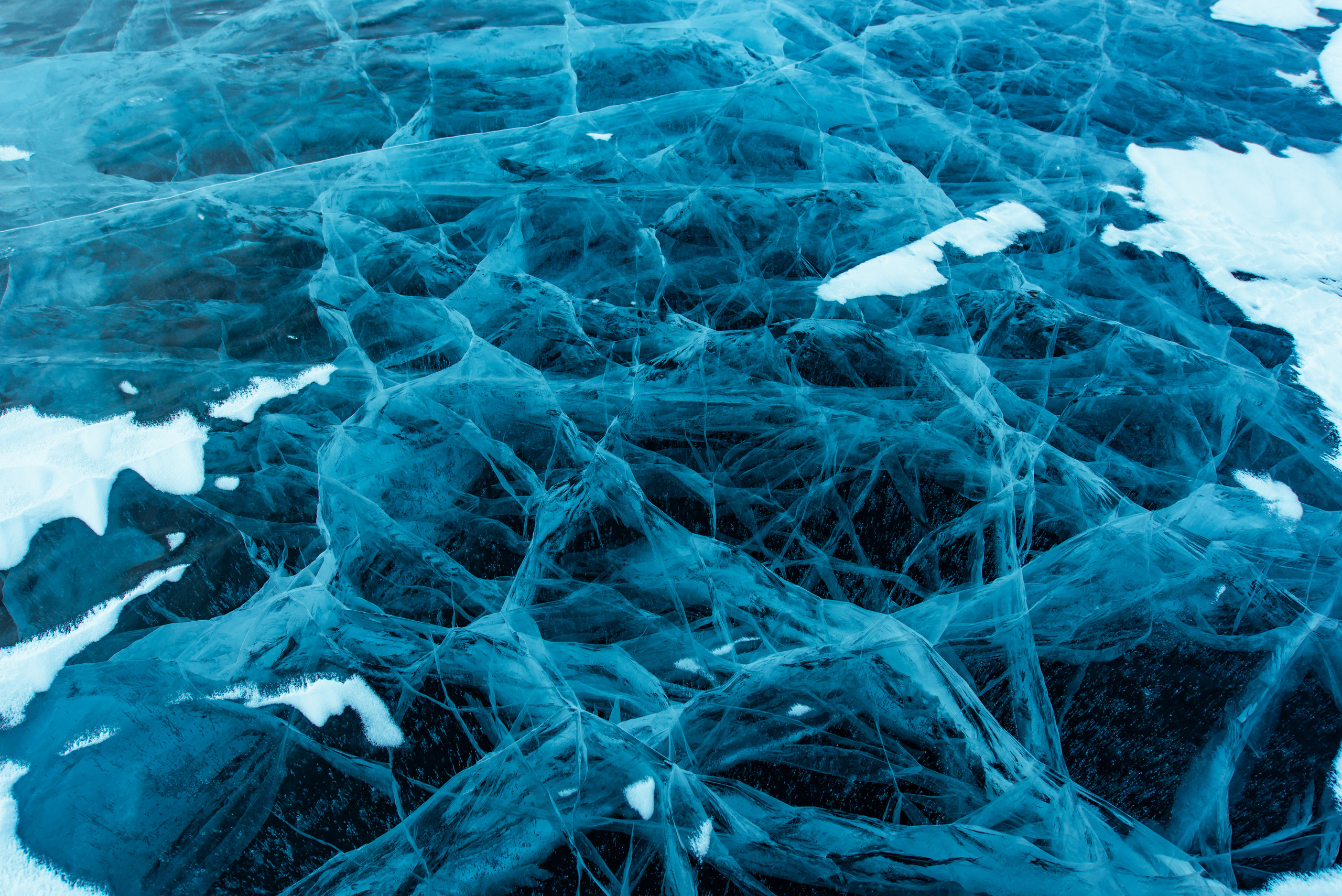 Голубой гладкий лед на Байкале с трещинами