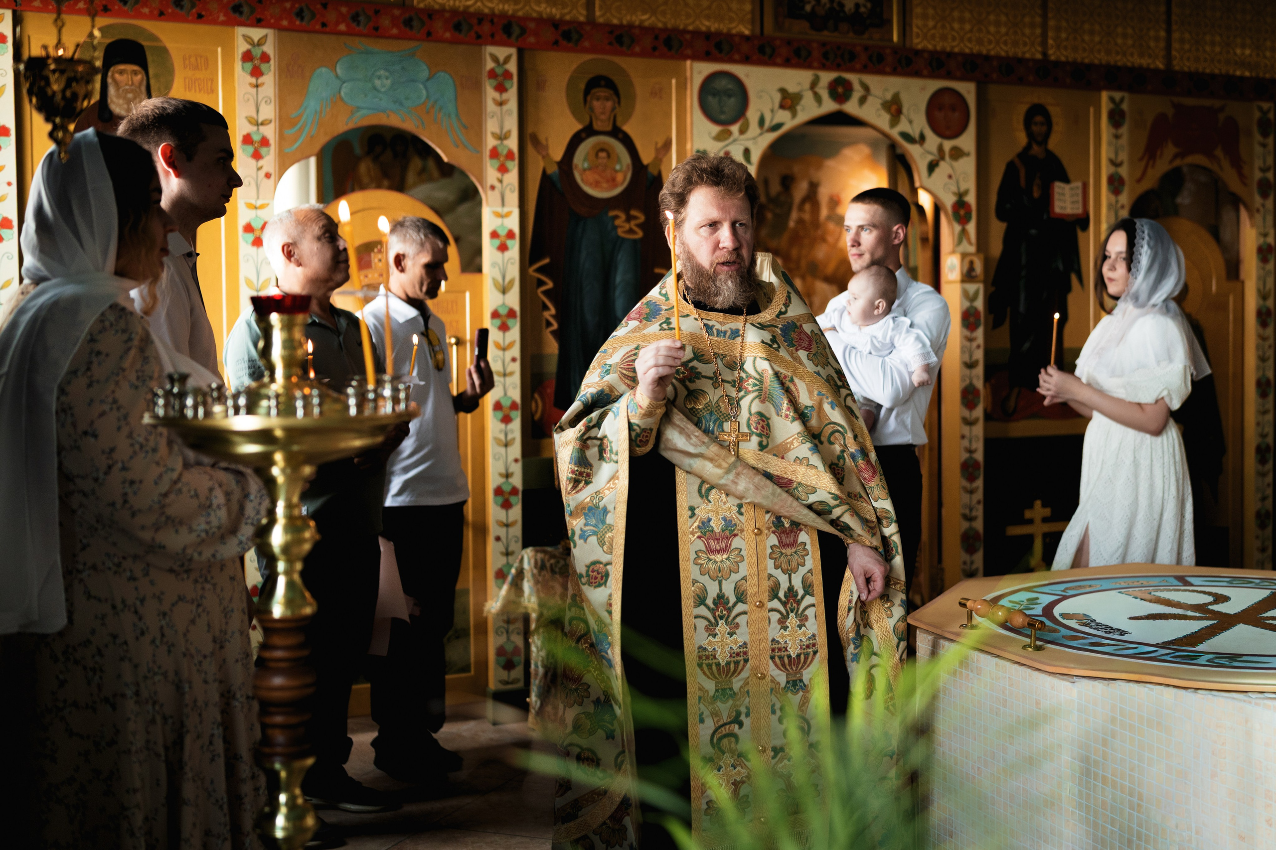 Батюшка с крёстными совершает крестный ход вокруг купели