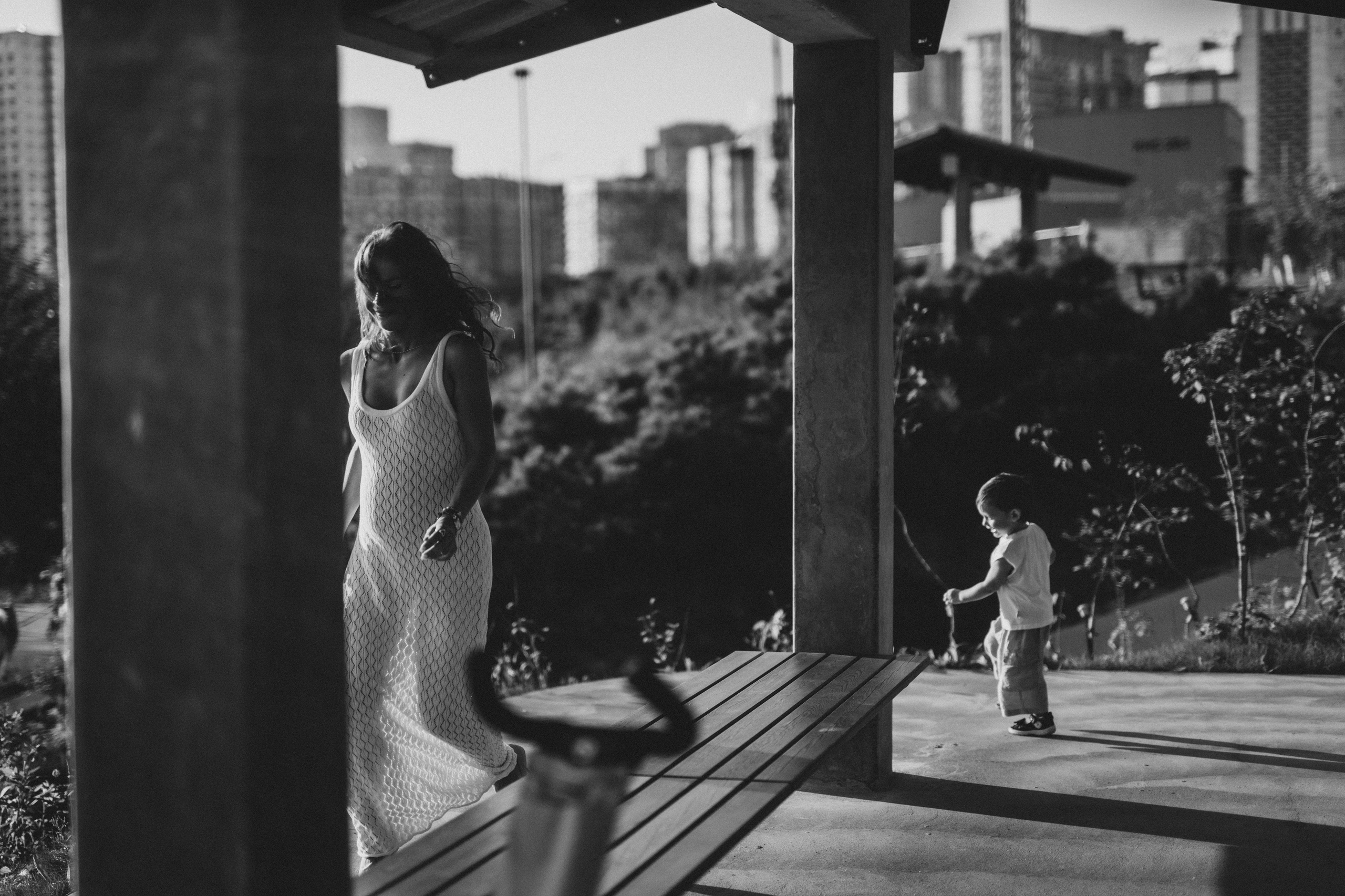 маленькая девочка держит за руки папу и маму на берегу моря