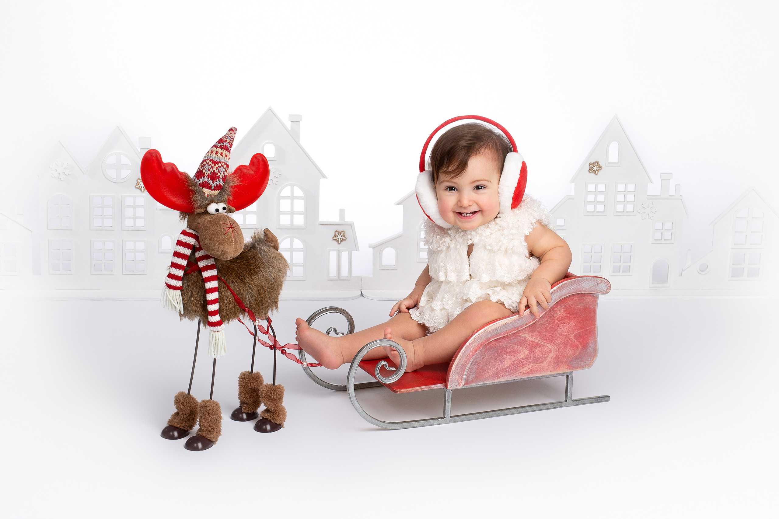 Маленькая девочка в наушниках на белом фоне.