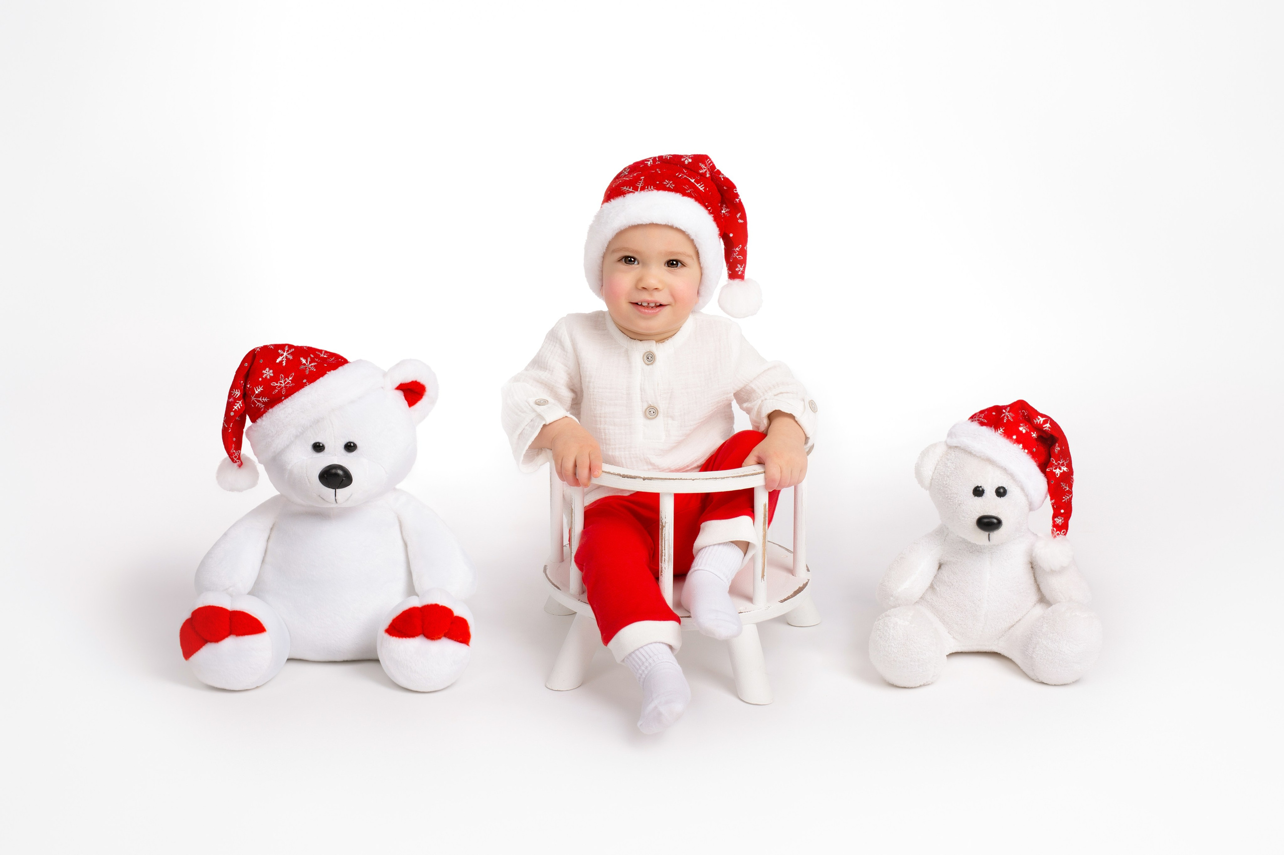 Три медведя в новогодних колпаках на белом фоне.