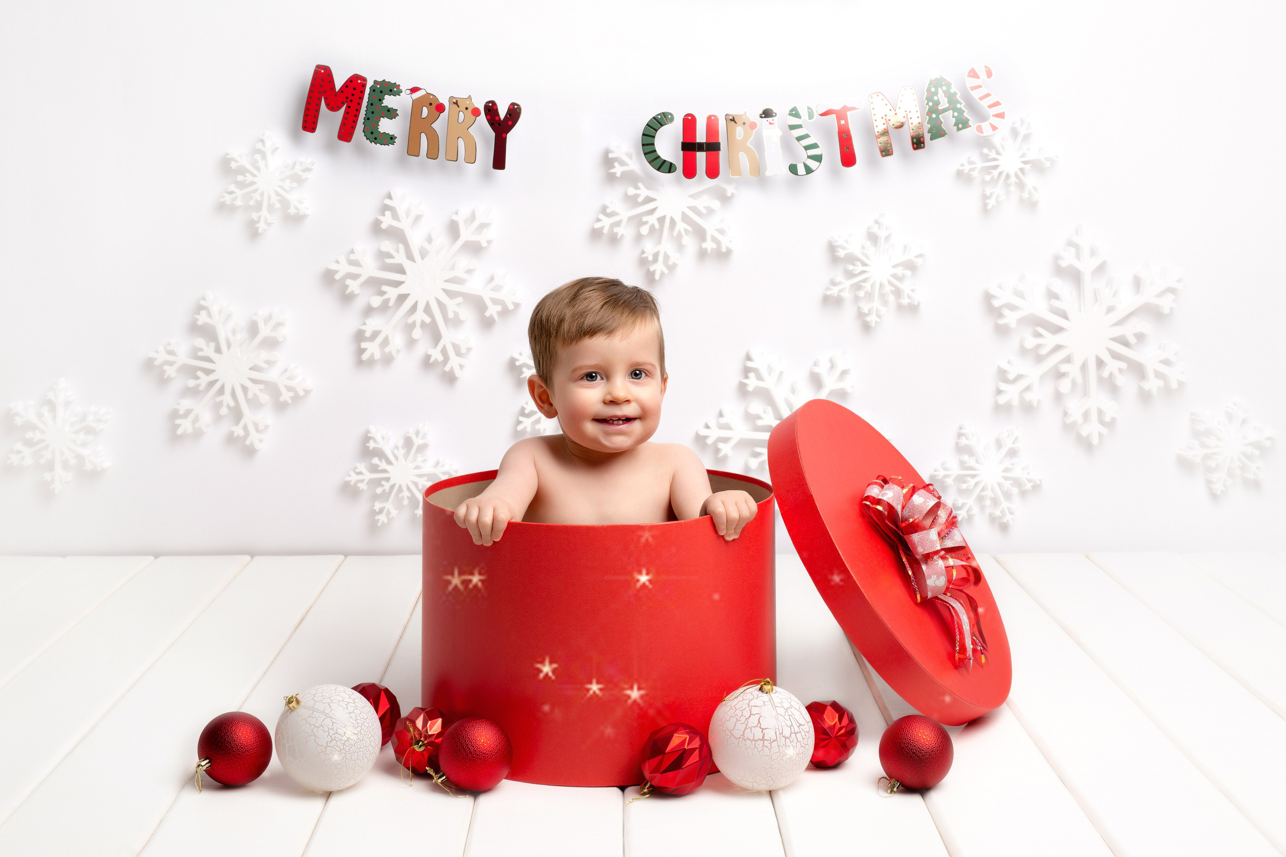 В большой подарочной коробке сидит годовалый малыш.