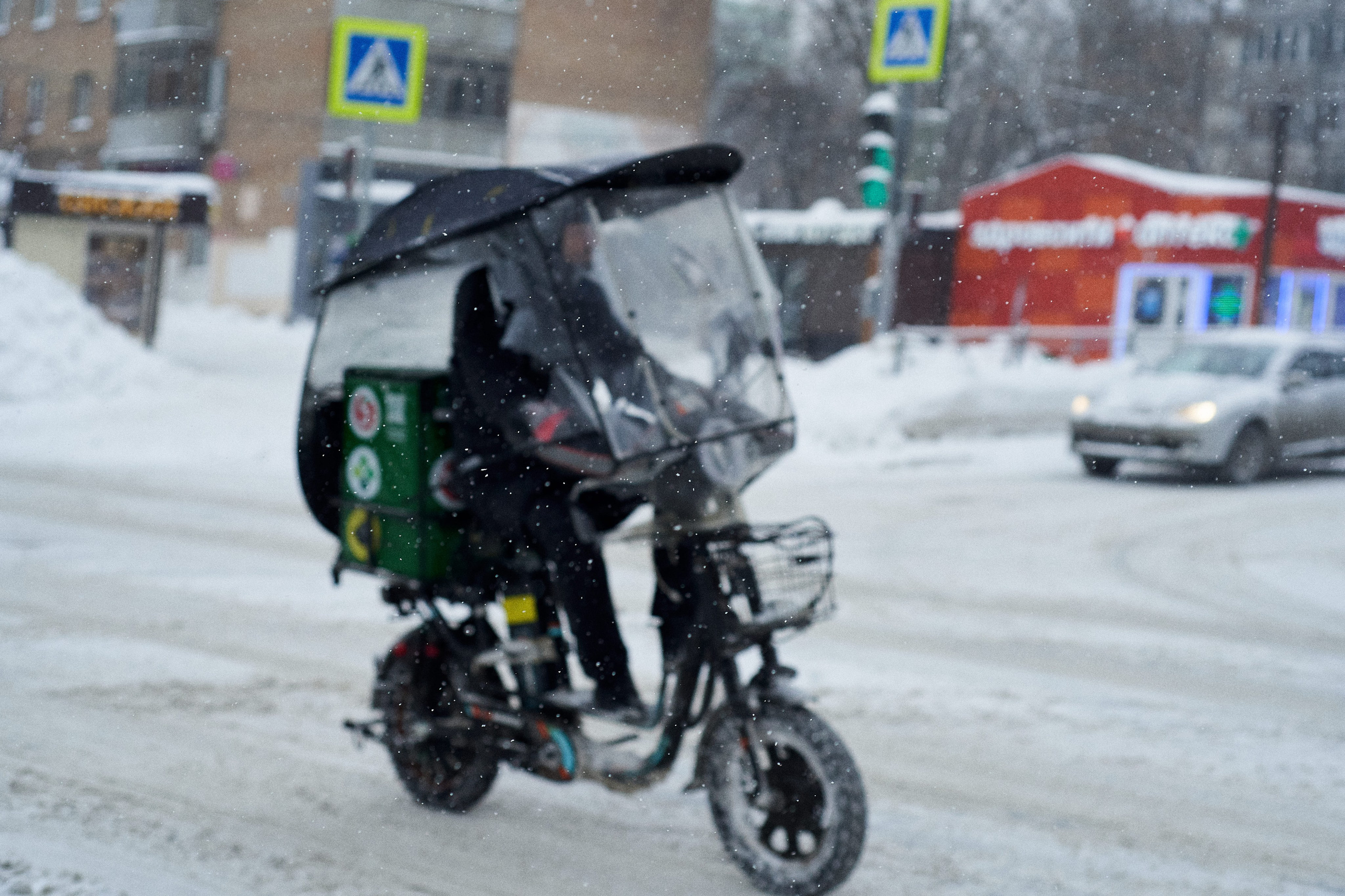 People on a snowy Moscow street. Russian residents walking through deep snow during winter in Moscow. Heavy snowfall covering the city.