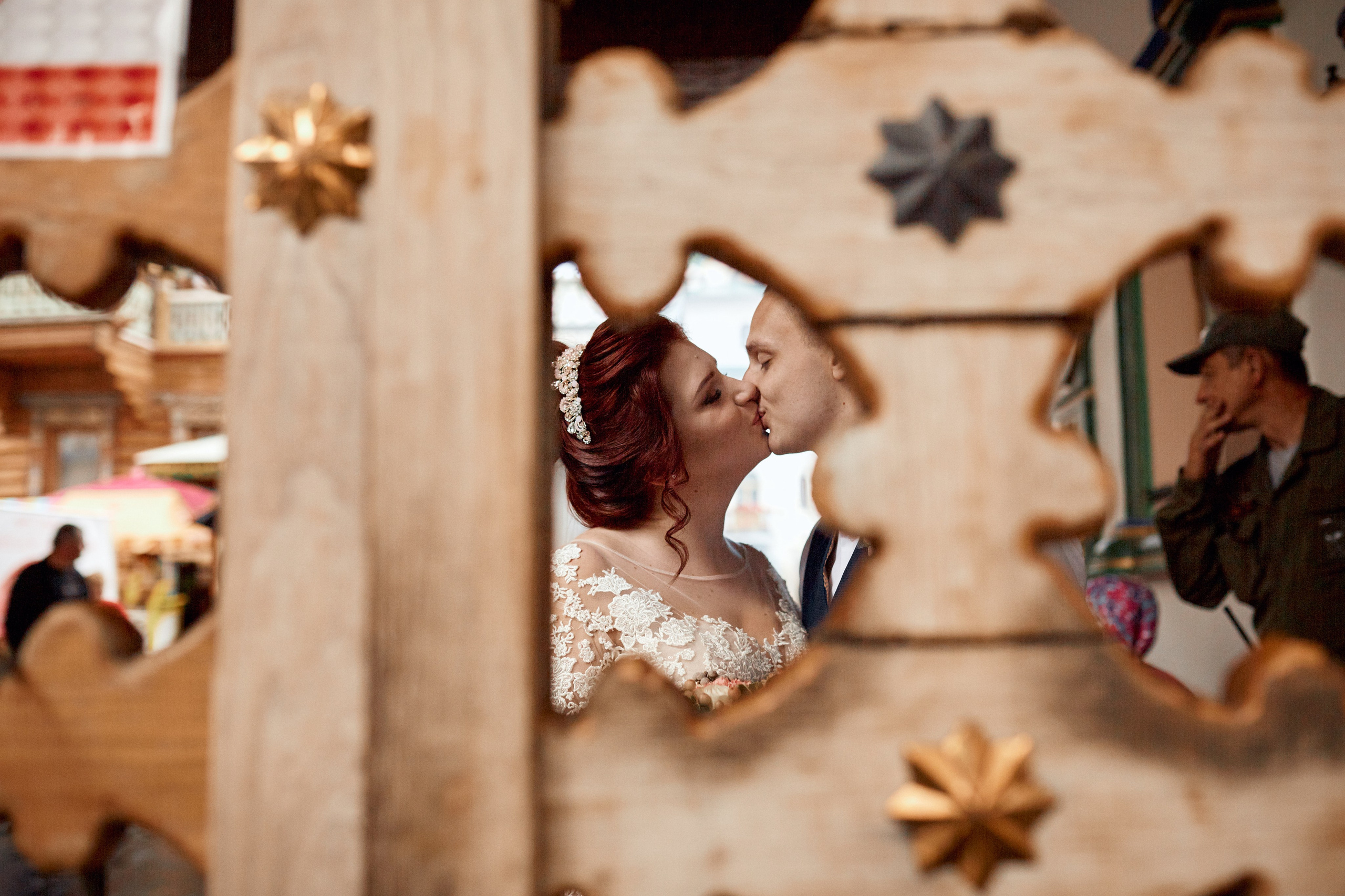 Фотосессия свадьбы в Измайловском кремле перед росписью - пример фотографии с невесты и жениха целующихся возле ворот