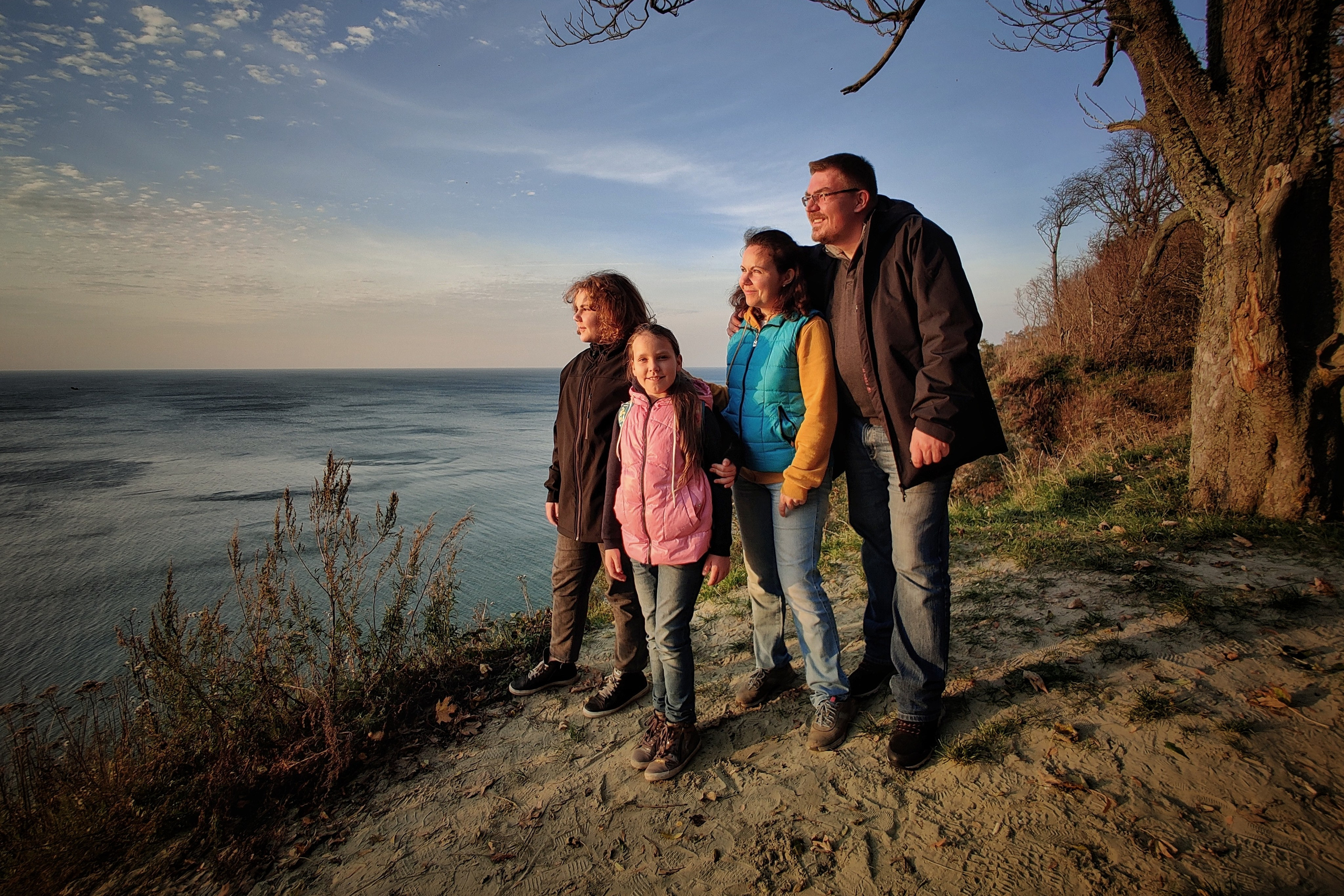 Четыре человека стоят на обрыве у Балтийского моря