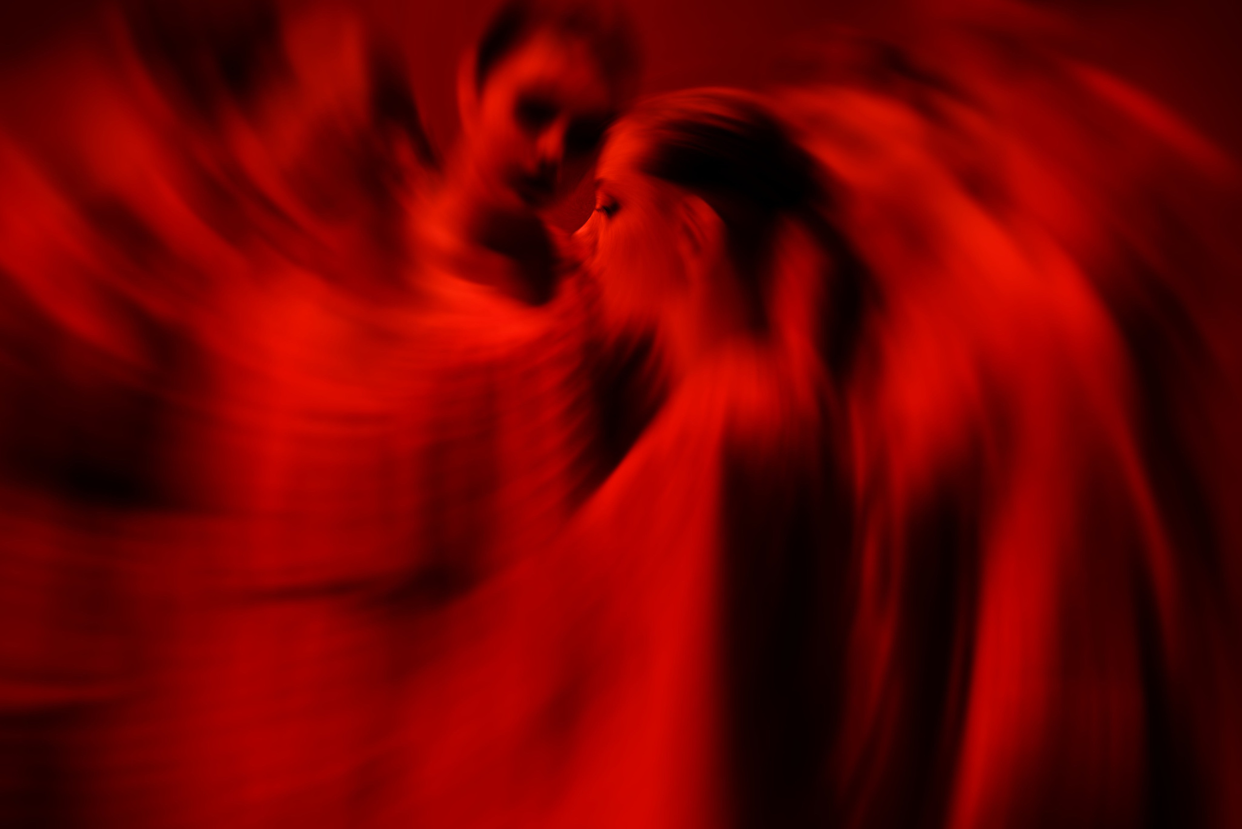 Две фигуры с эффектом красного вихря и размытия движения, абстрактная художественная композиция, страстная атмосфера