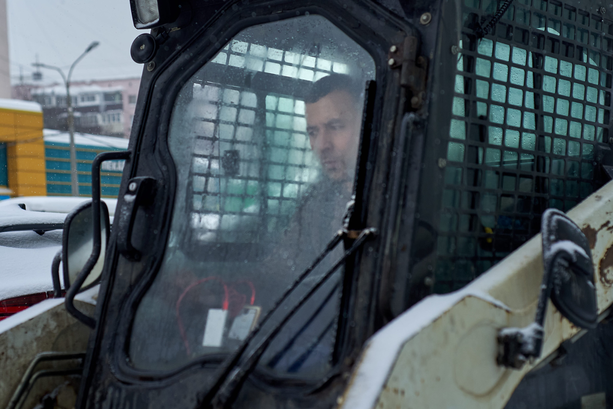 Snow removal in Moscow. Tractor clearing snow from a city street during heavy snowfall in Moscow, Russia.