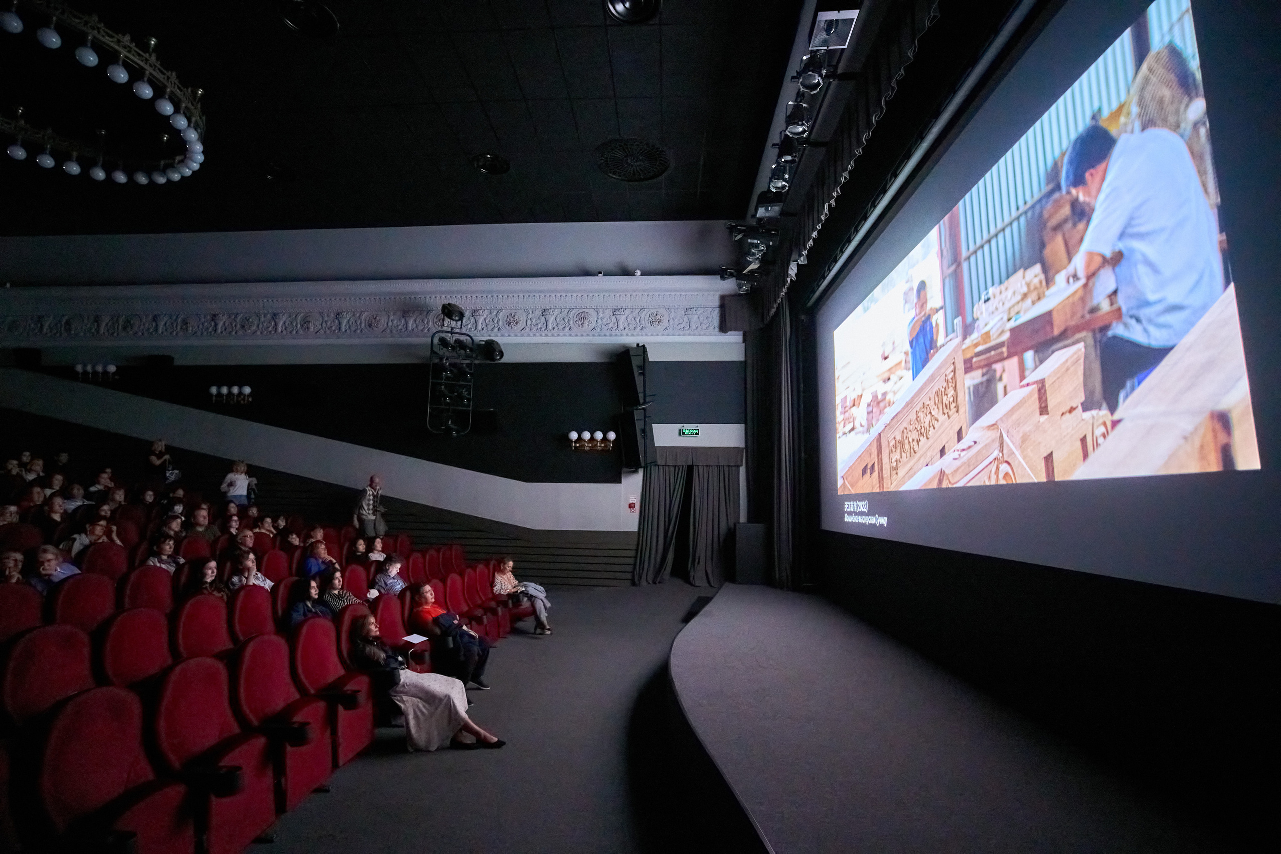 Зал кинотеатра Иллюзион. Зрители в темном зале смотрят на экран. Китайское кино в рамках кинофестиваля 2023