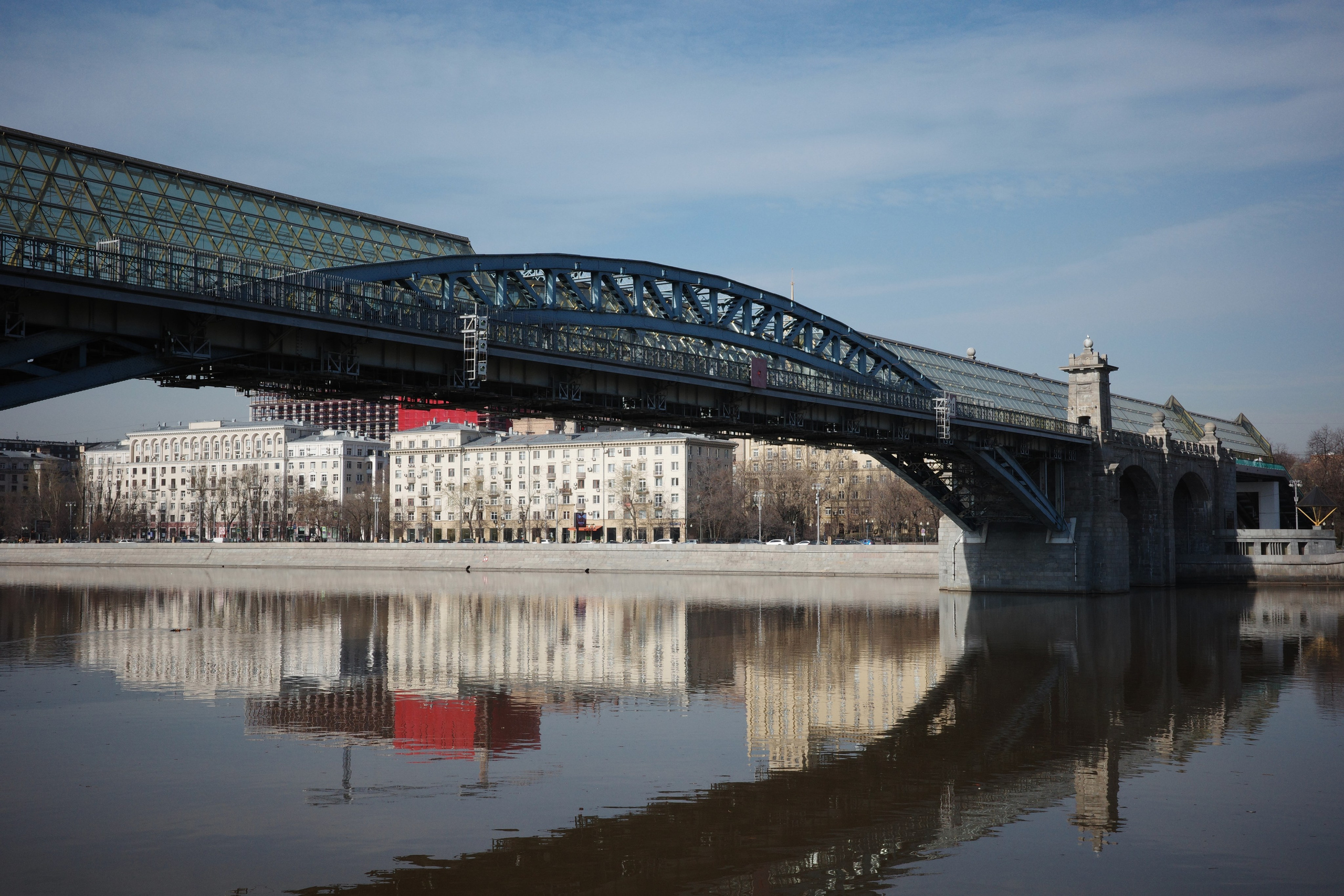 Андреевский пешеходный мост с арочной стеклянной крышей, отражение в Москве-реке
