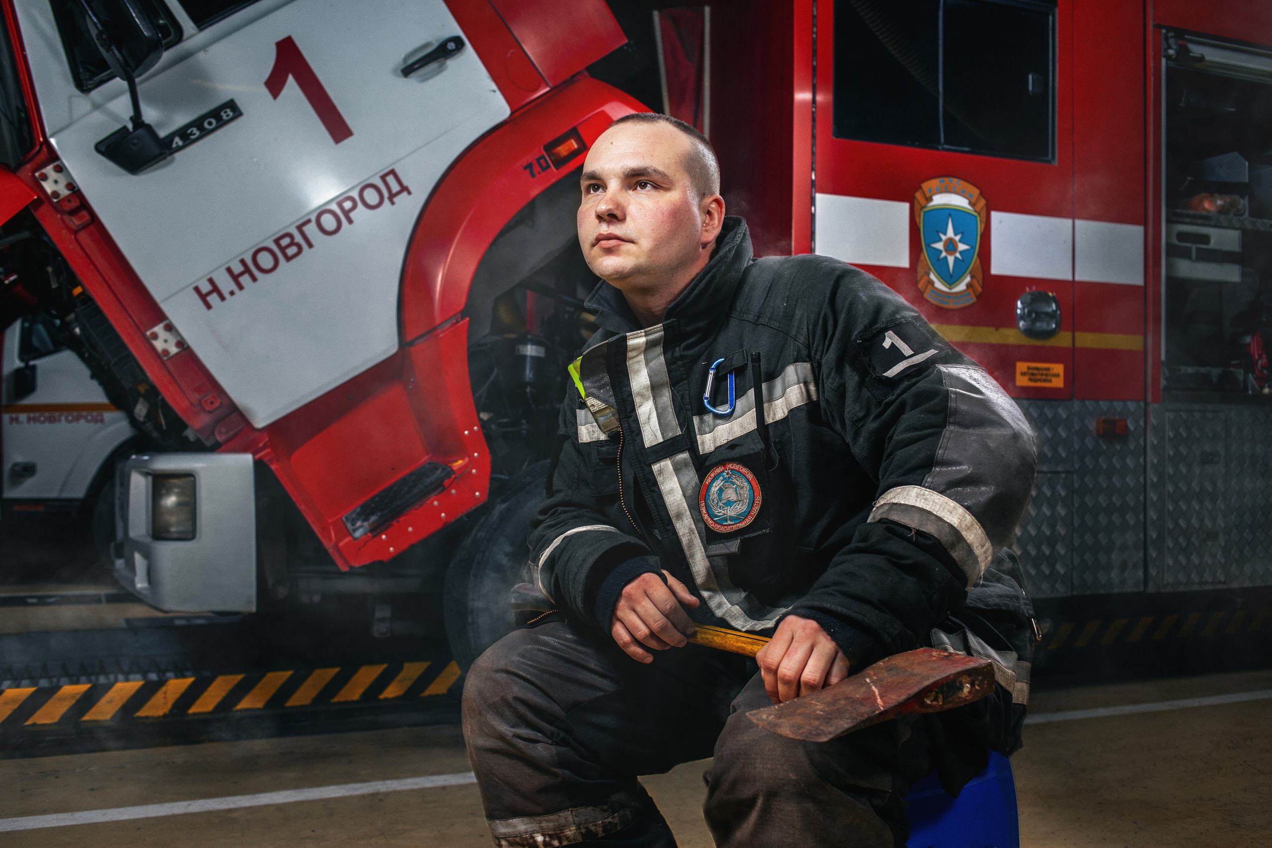 Съемка пожарного в пожарной части рядом с автомобилем