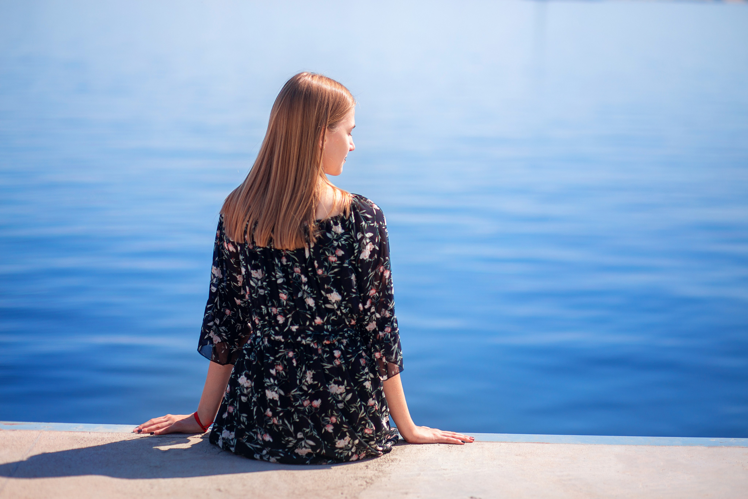 Девушка сидит и смотрит на воду, женская фотосессия