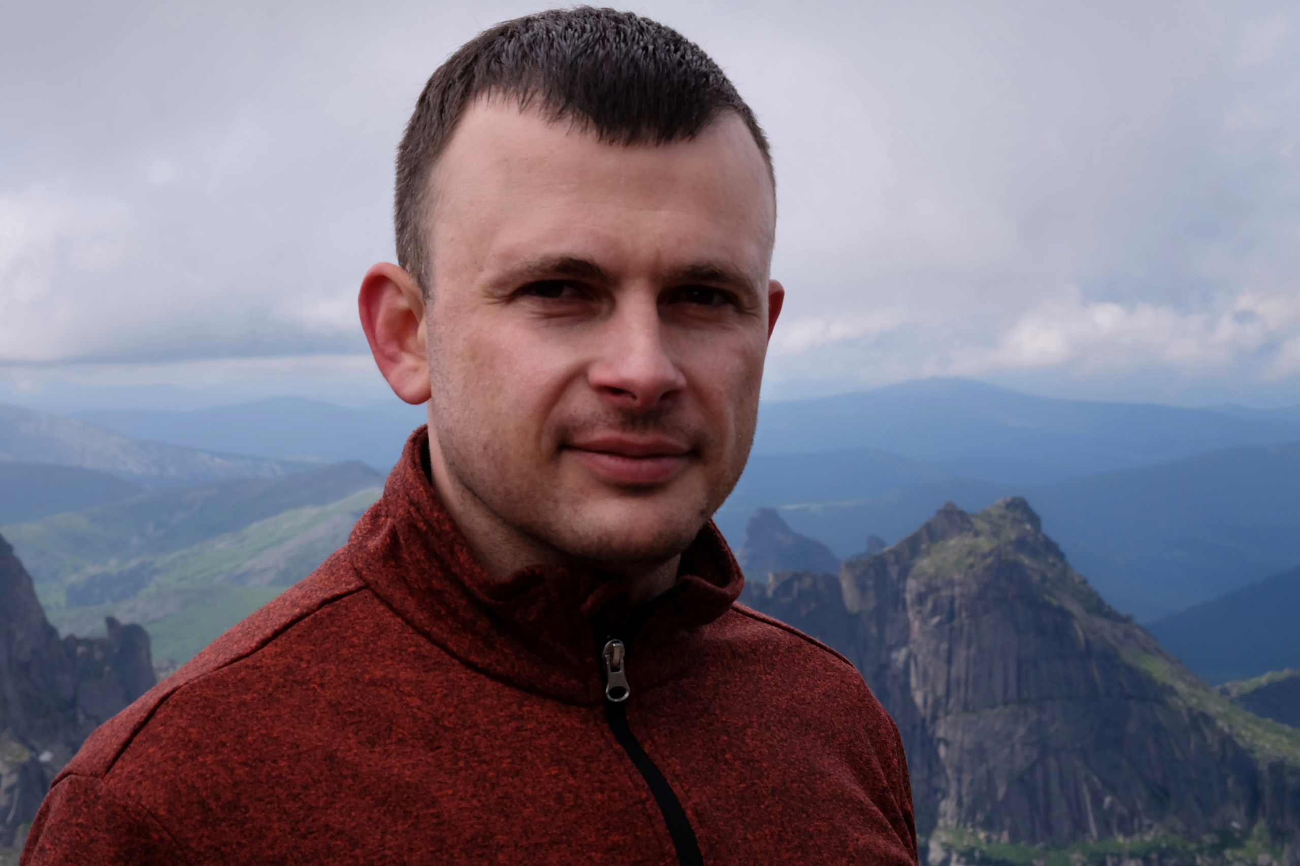 Данил Макаренко, финансовый тренер и путешественник, на фоне гор во время восхождения