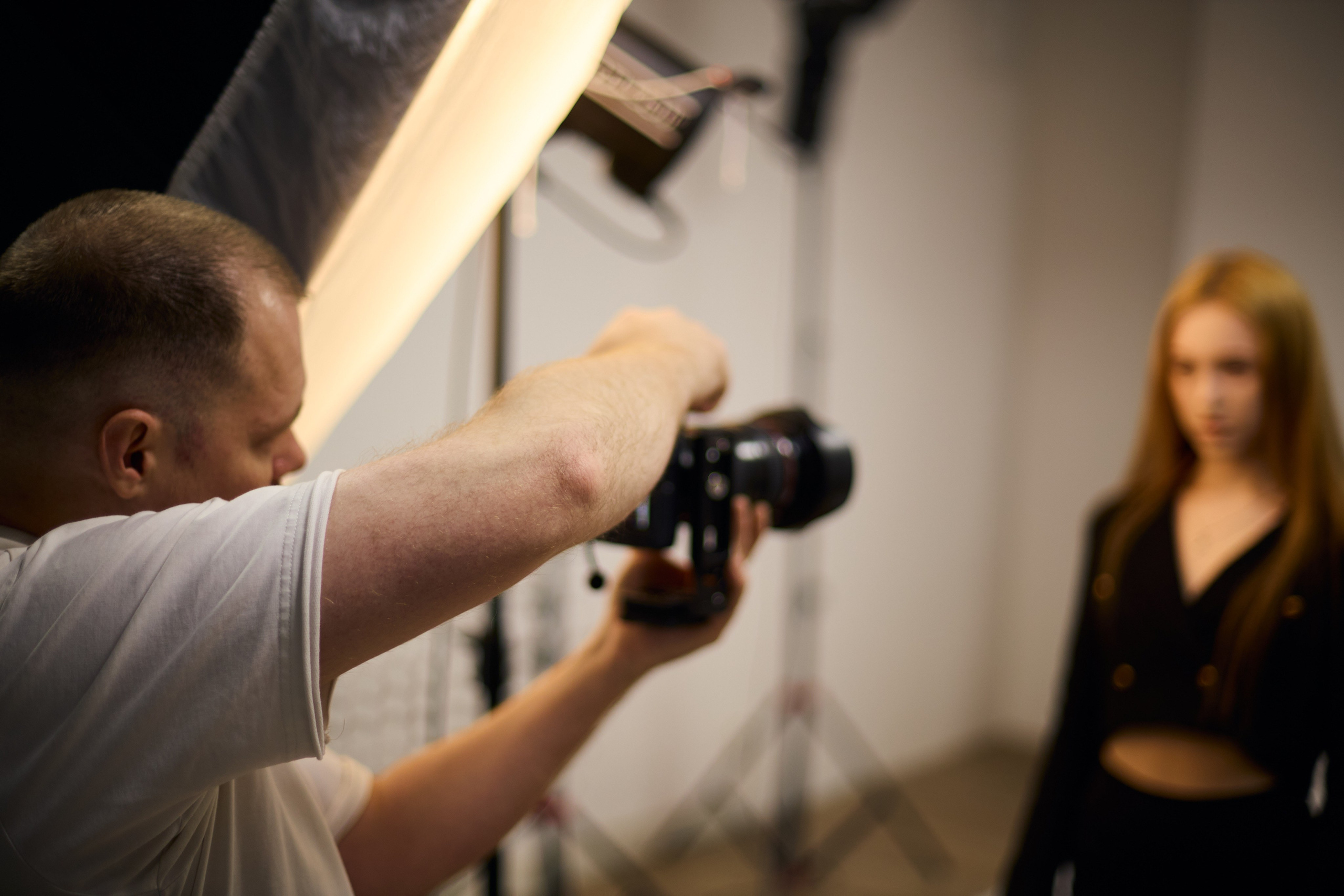 Работа фотографа с моделью в профессиональной студии