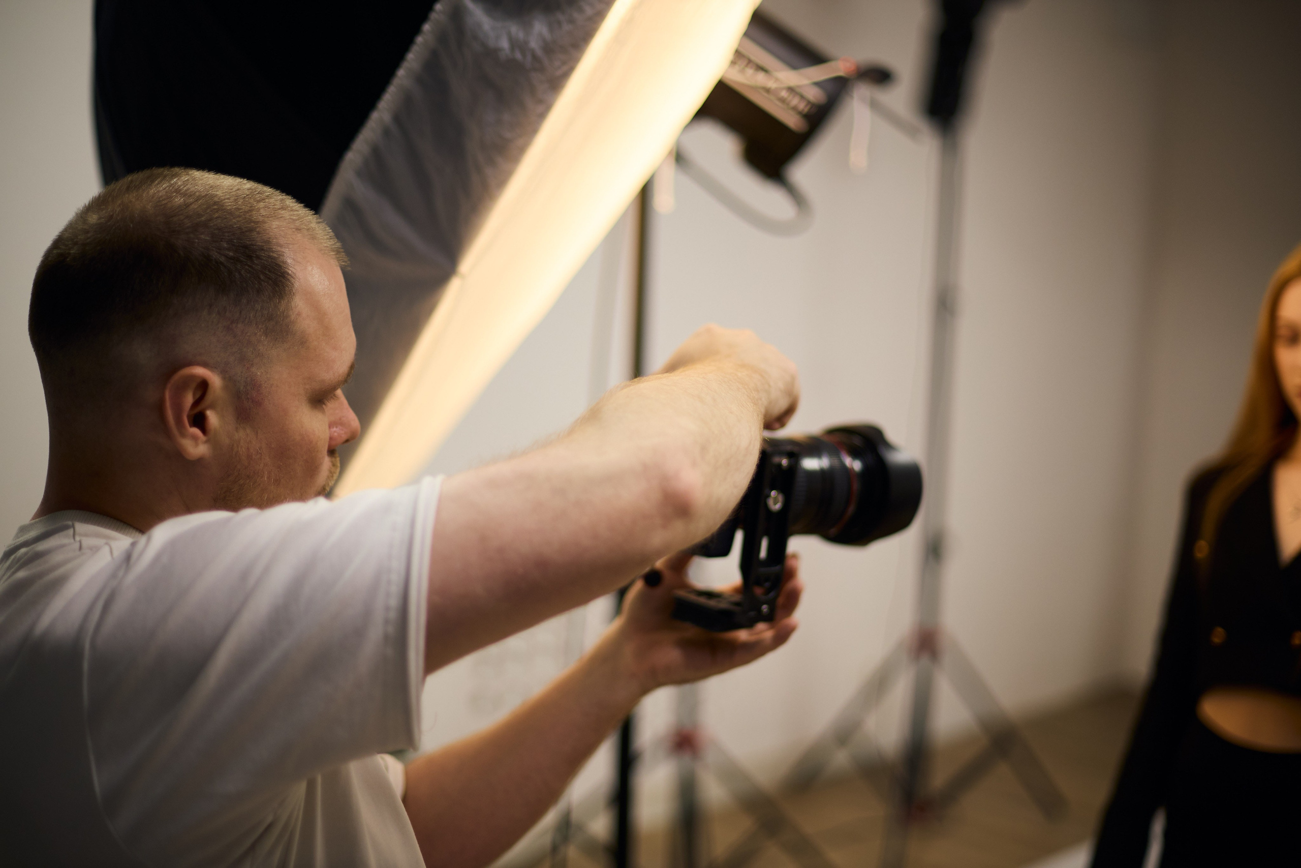 Фотограф настраивает свет и оборудование в студии — процесс профессиональной фотосъемки бизнес-портретов.