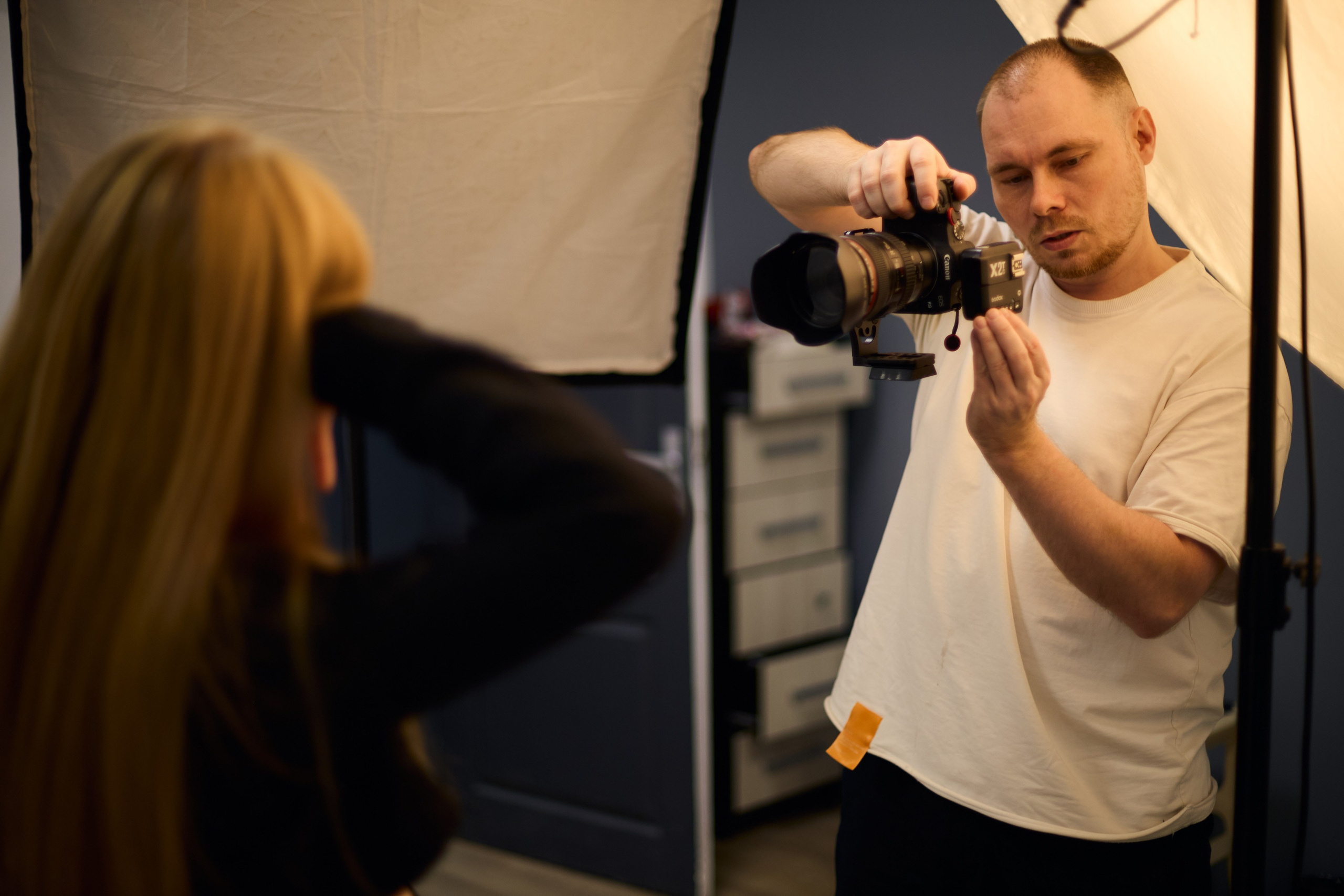 Фотограф ведет съемку портрета в студии — процесс создания профессионального бизнес-фото.