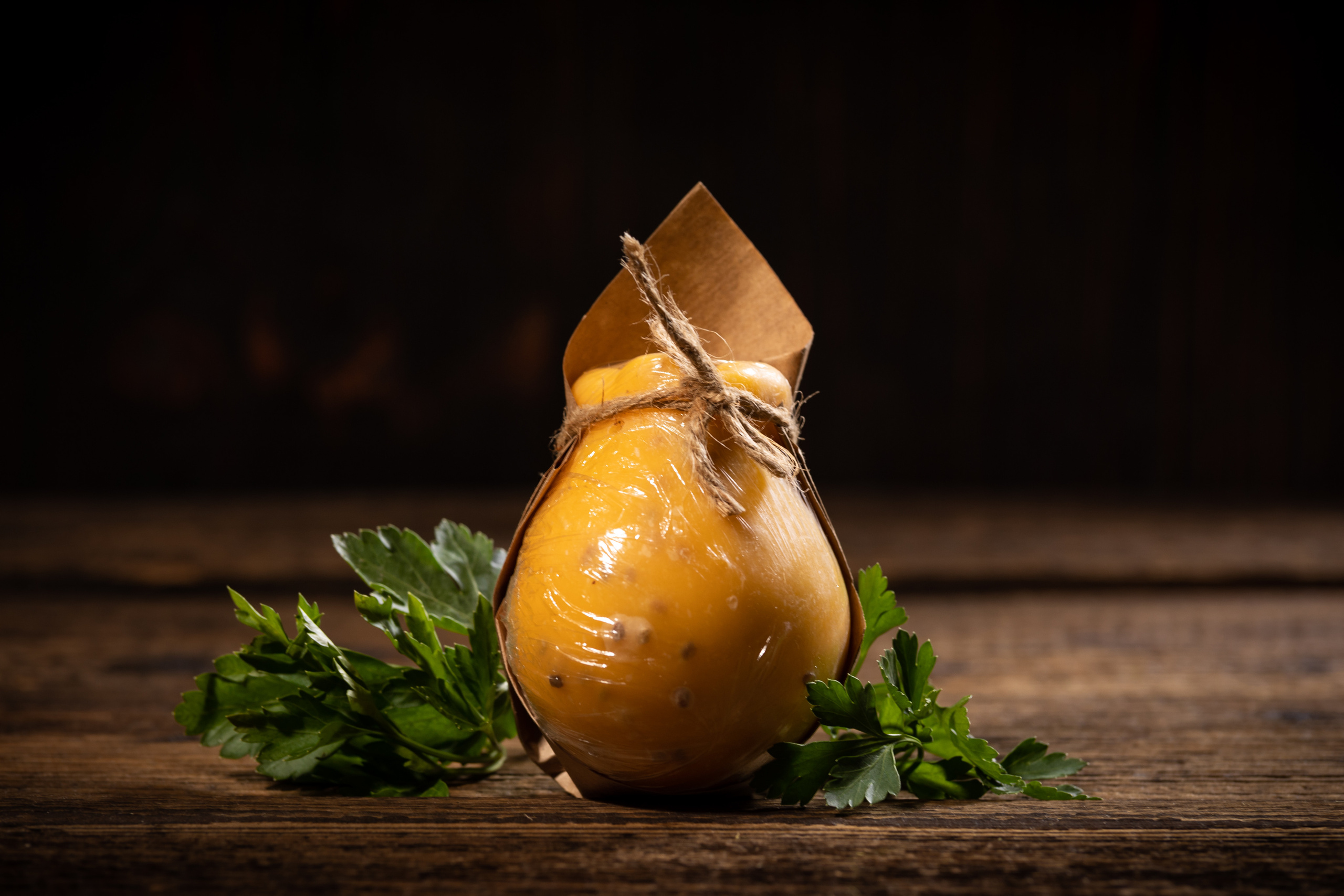 Упакованная в крафтовую бумагу головка кочокавалло с пажитником. Подарочная упаковка