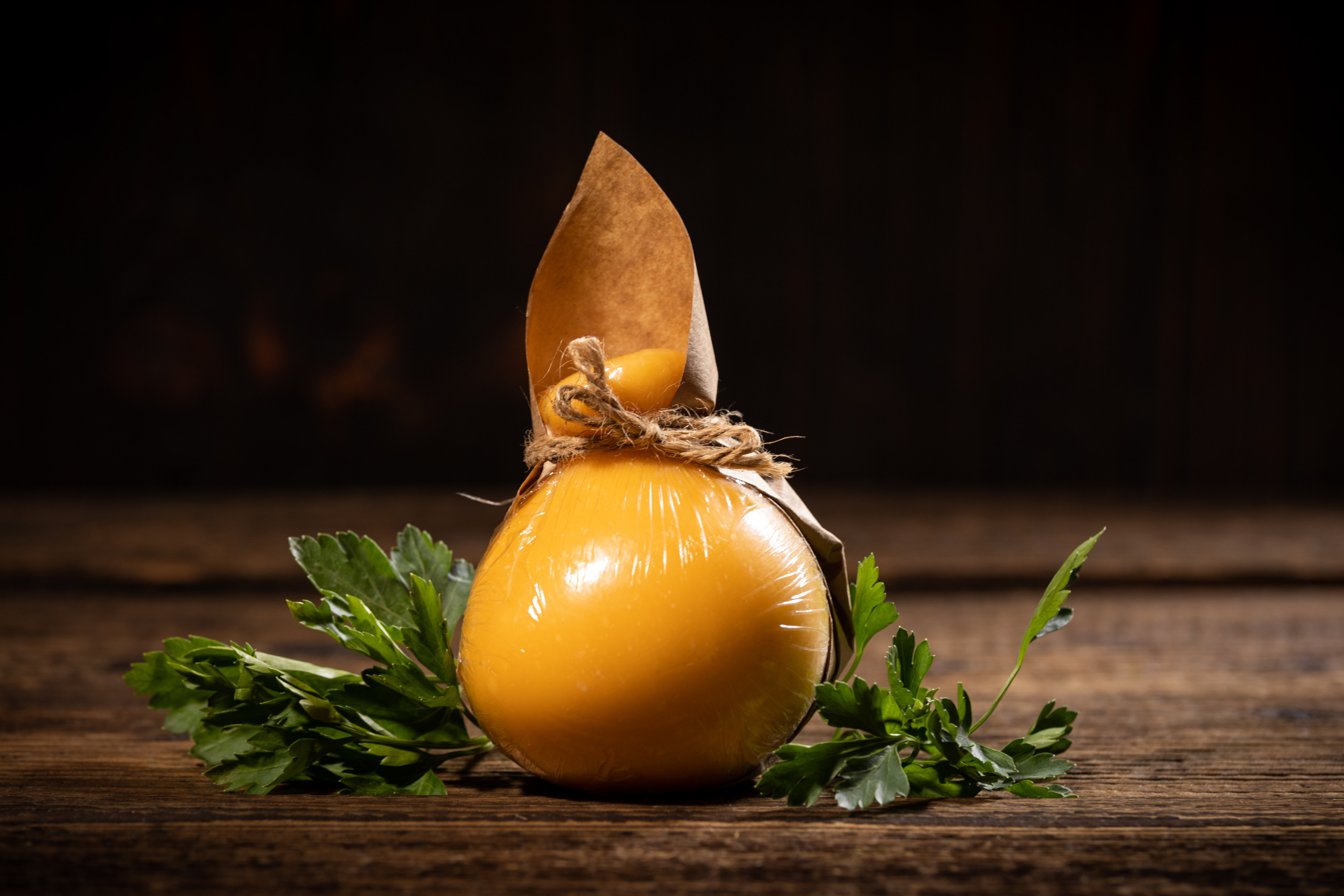 Упакованная в крафтовую бумагу головка кочокавалло классический. Подарочная упаковка