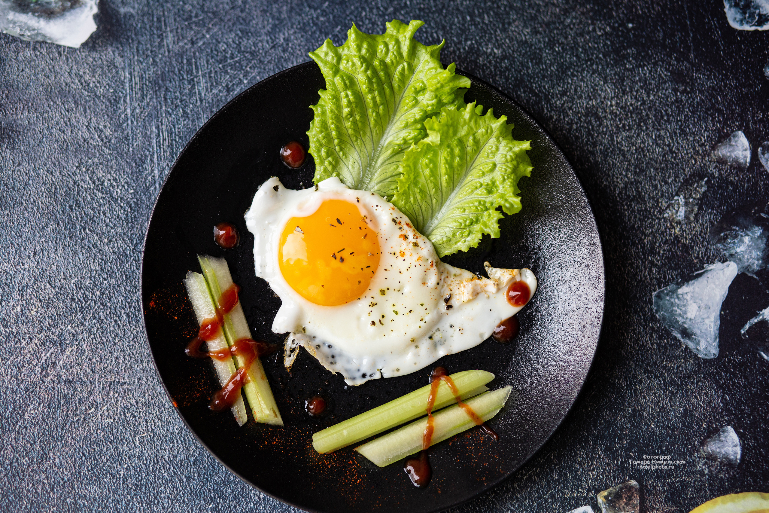 яичница, фуд фото, лист салата, черная тарелка, стильное фото завтрака, завтрак, глазунья, сельдерей, ресторанная подача яичницы, кетчуп, лед, лимон, текстура, foodphoto