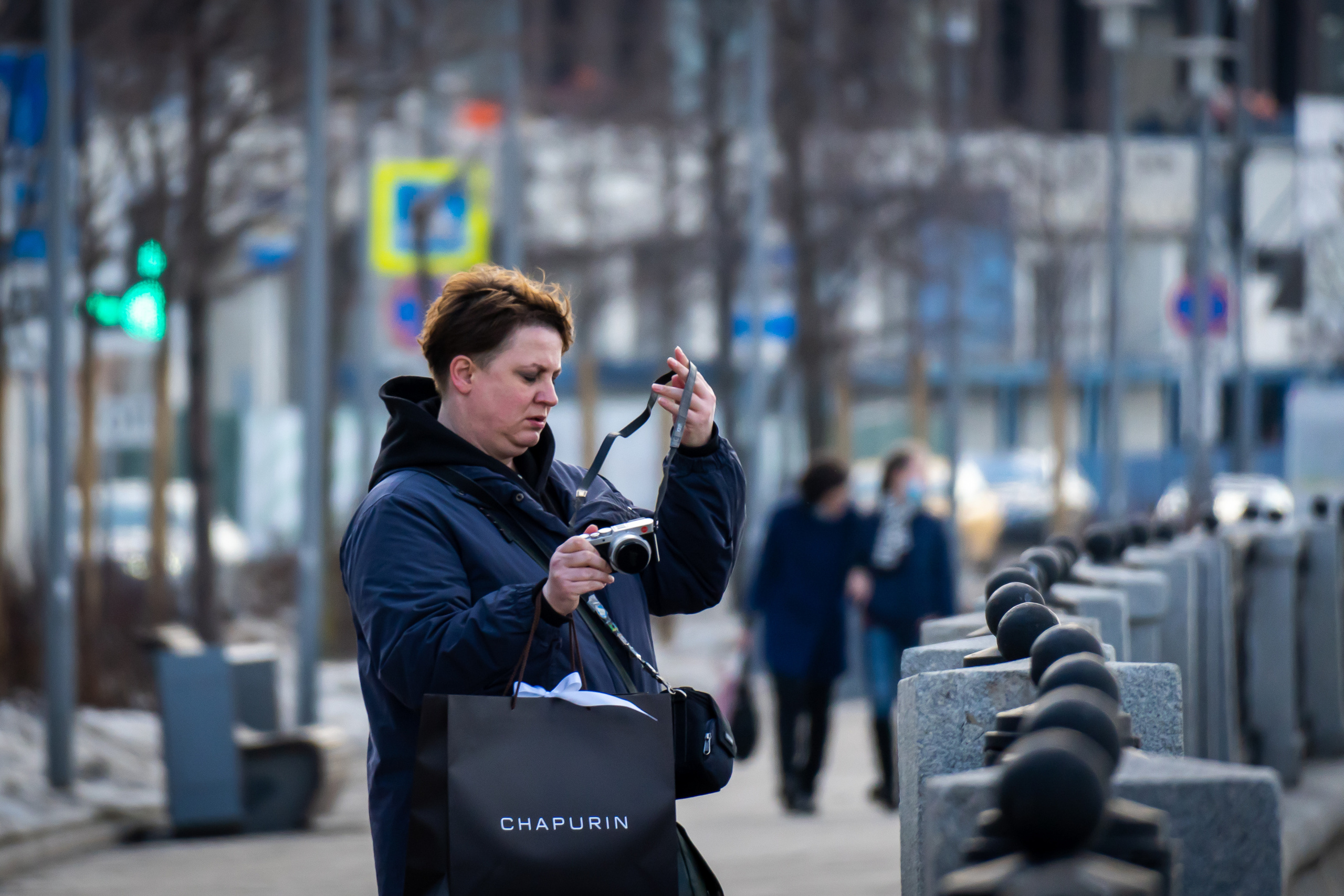 Девушка на Саввинской набережной в Москве с фотоаппаратом Leica и пакетом Chapurin