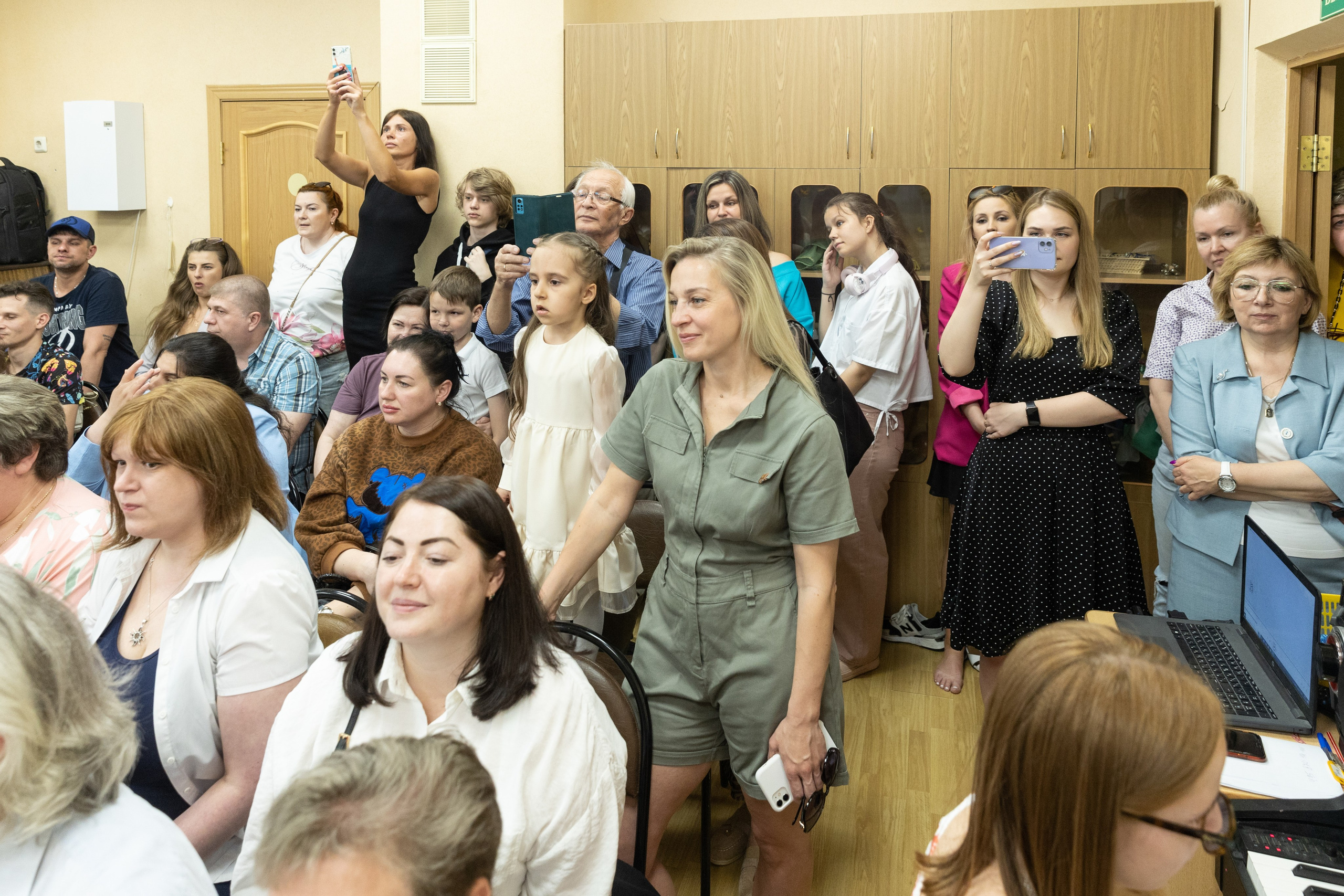 Родители на выпускном внимательно смотрят торжественную часть