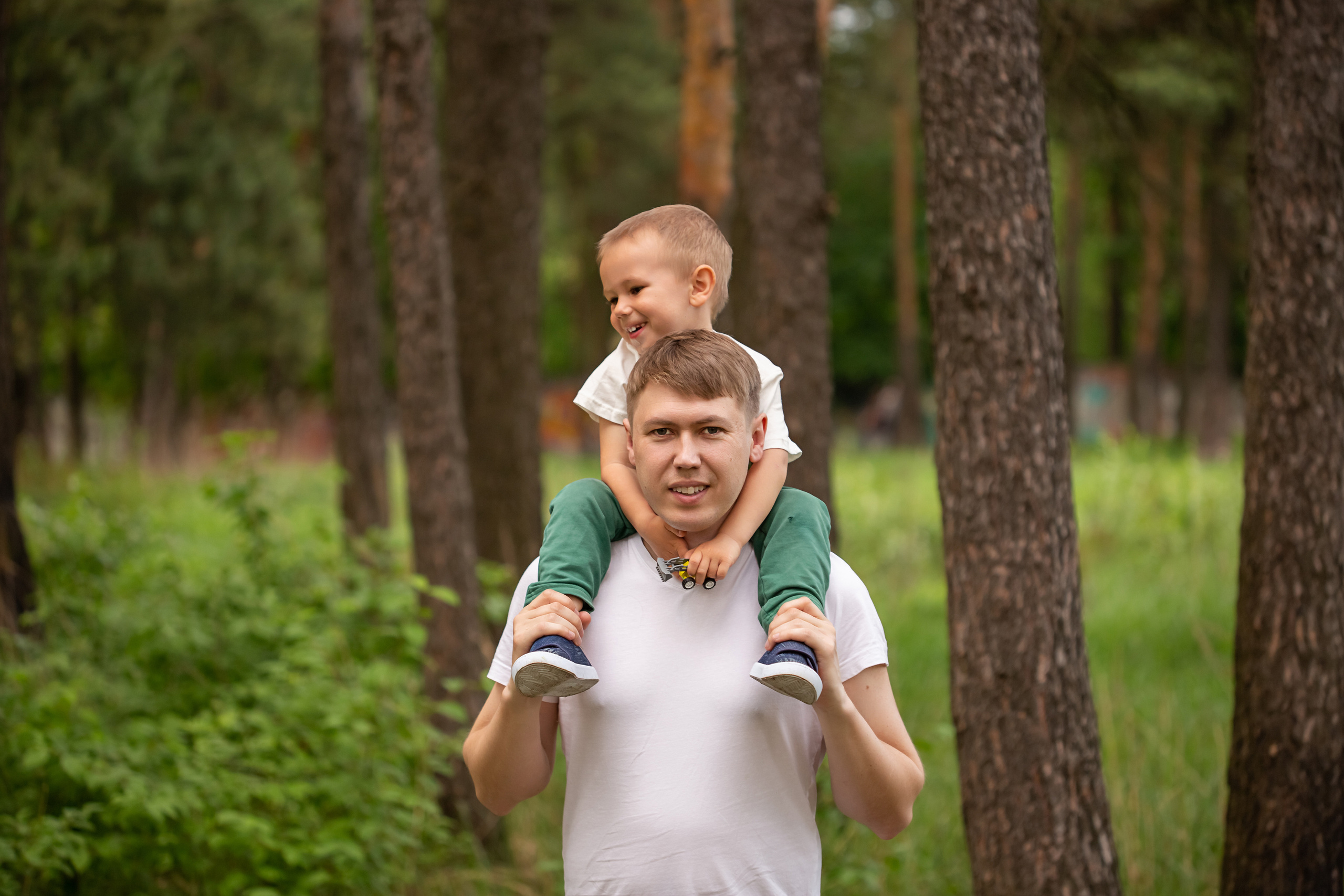 Папа несет на плечах маленького сына