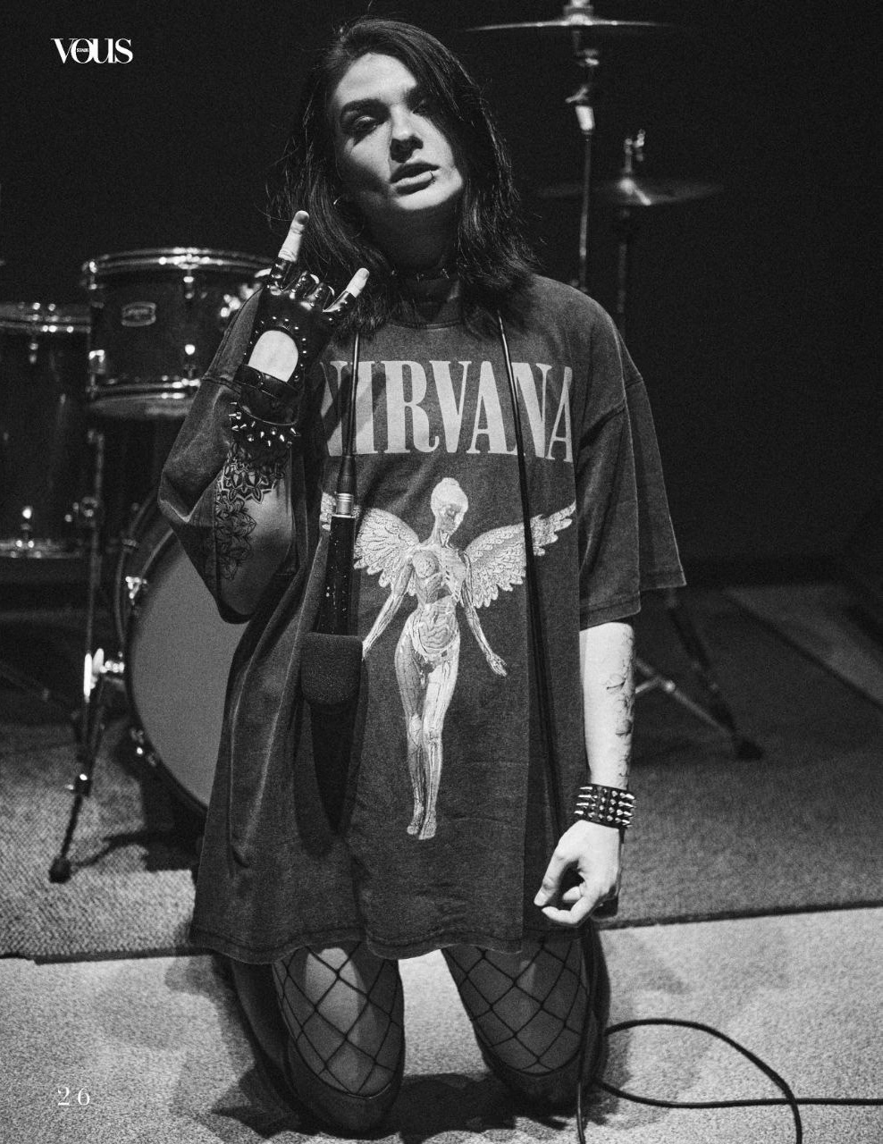 Молодая девушка в чулках и футболке Нирвана