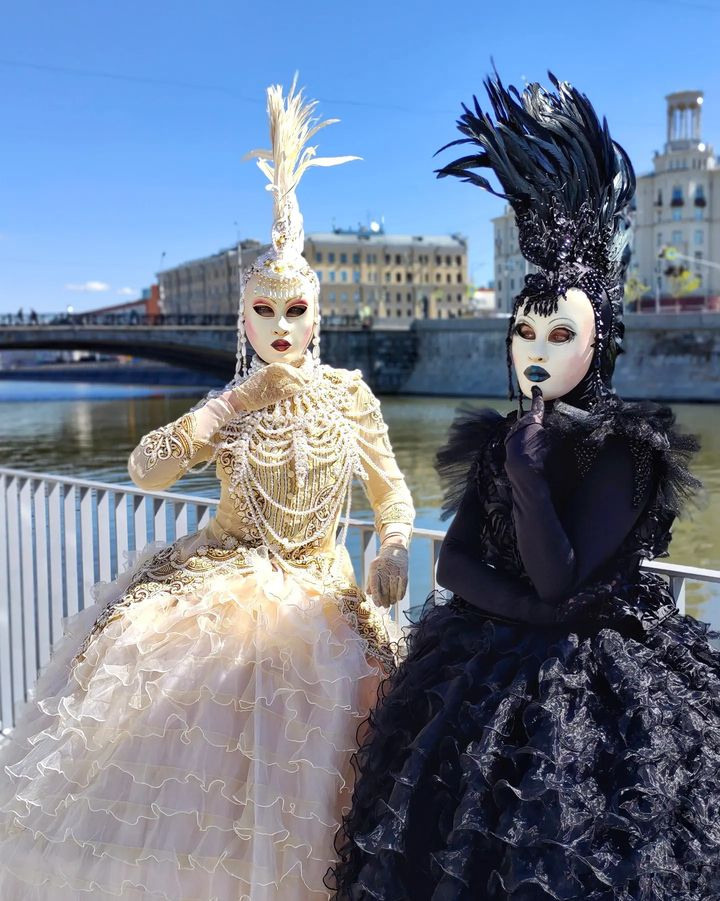 Два мима на встрече гостей в шикарных платьях на набережной реки Москва.