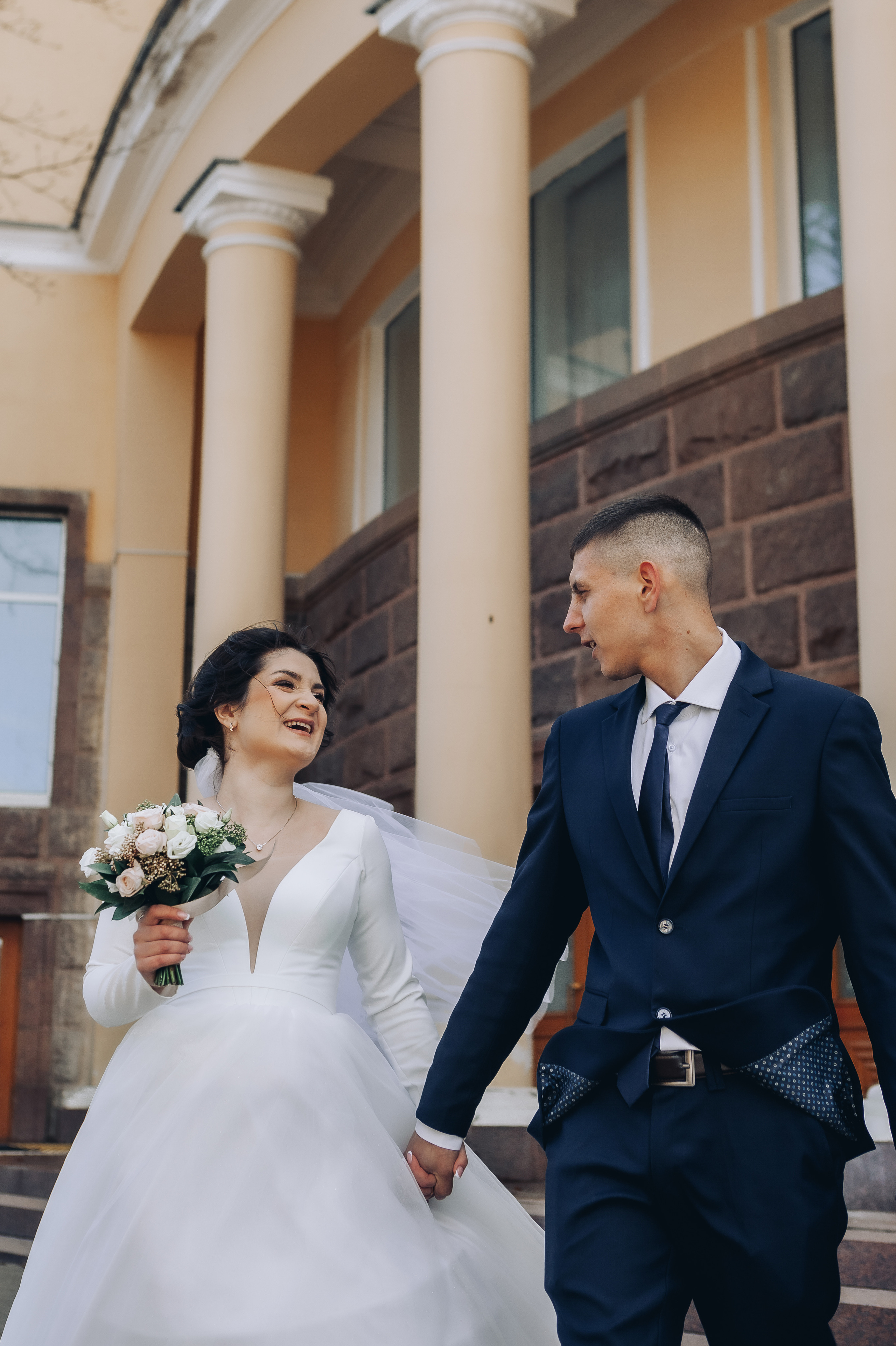 Молодожены радостно смотрят друг на друга на переднем плане, а позади Драмтеатр Смоленск