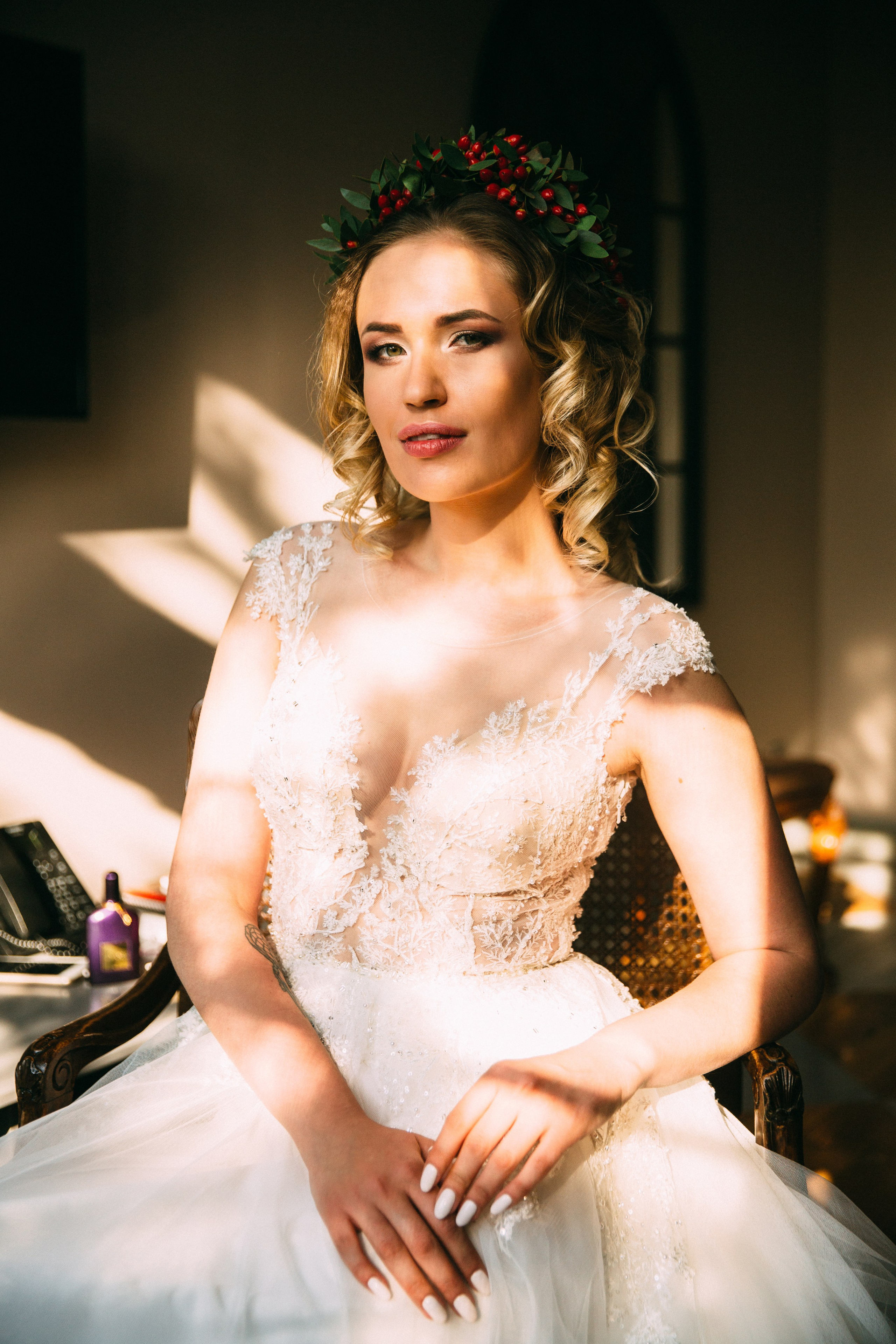 Невеста в кружевном платье стоит в лучах закатного солнца, красивая тень падает на её фигуру. Эмоциональный художественный кадр свадебной фотосессии.