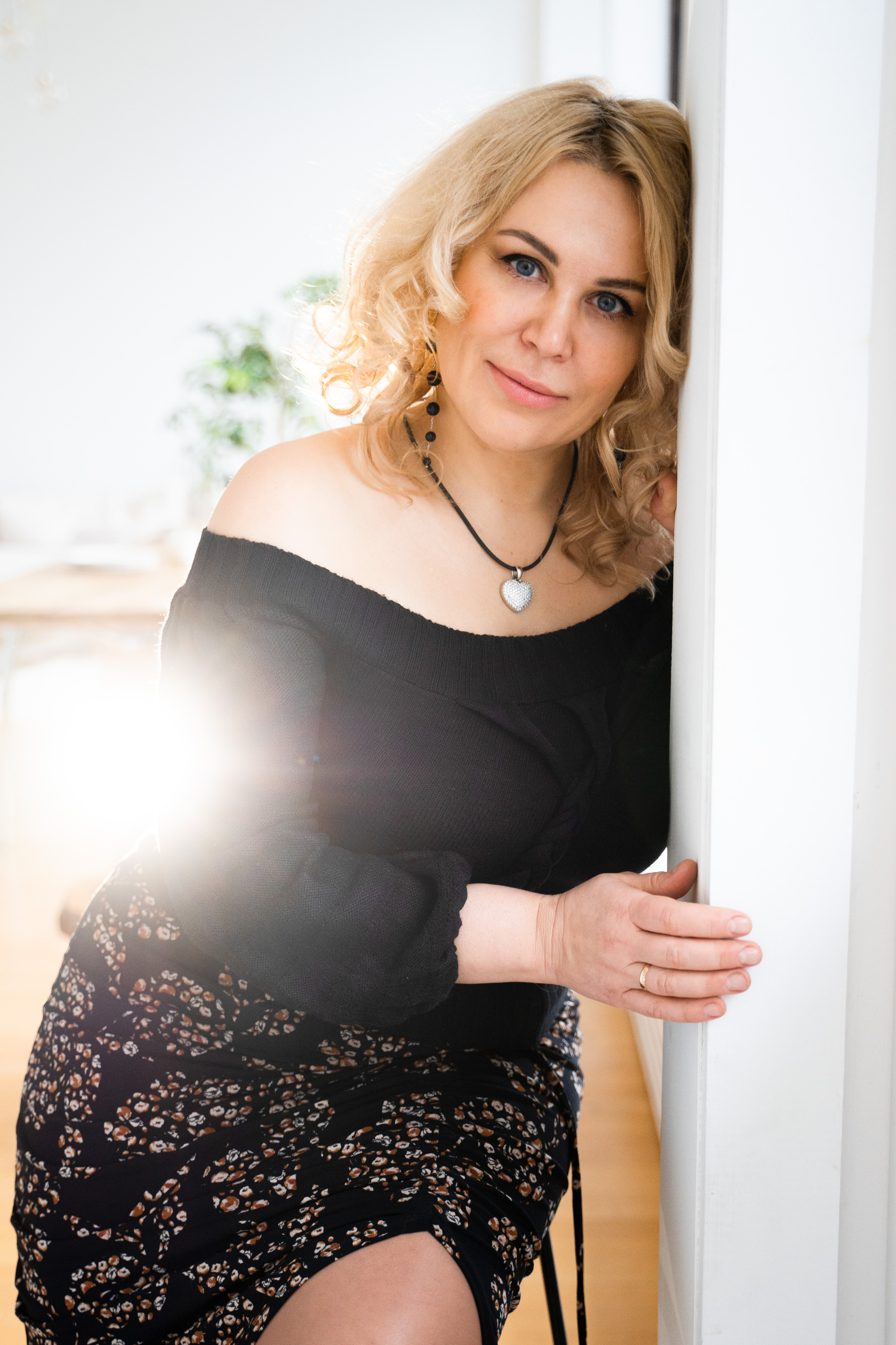 Женщина разговоривает по телефону в Невской Ратуше, ветер раздувает ее волосы.