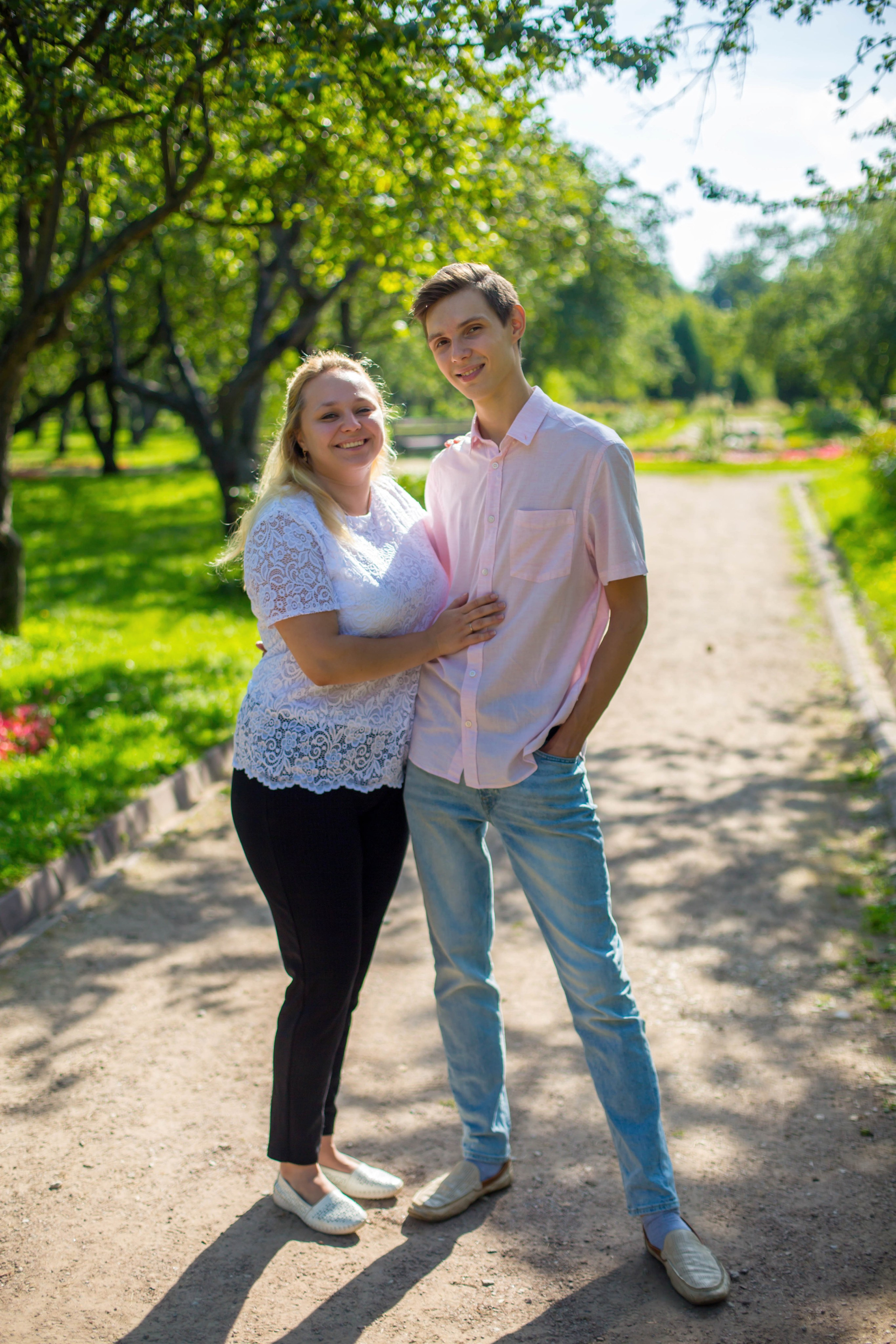 Влюбленные идут по аллее парка. Репортажный стиль до свадебной съемки