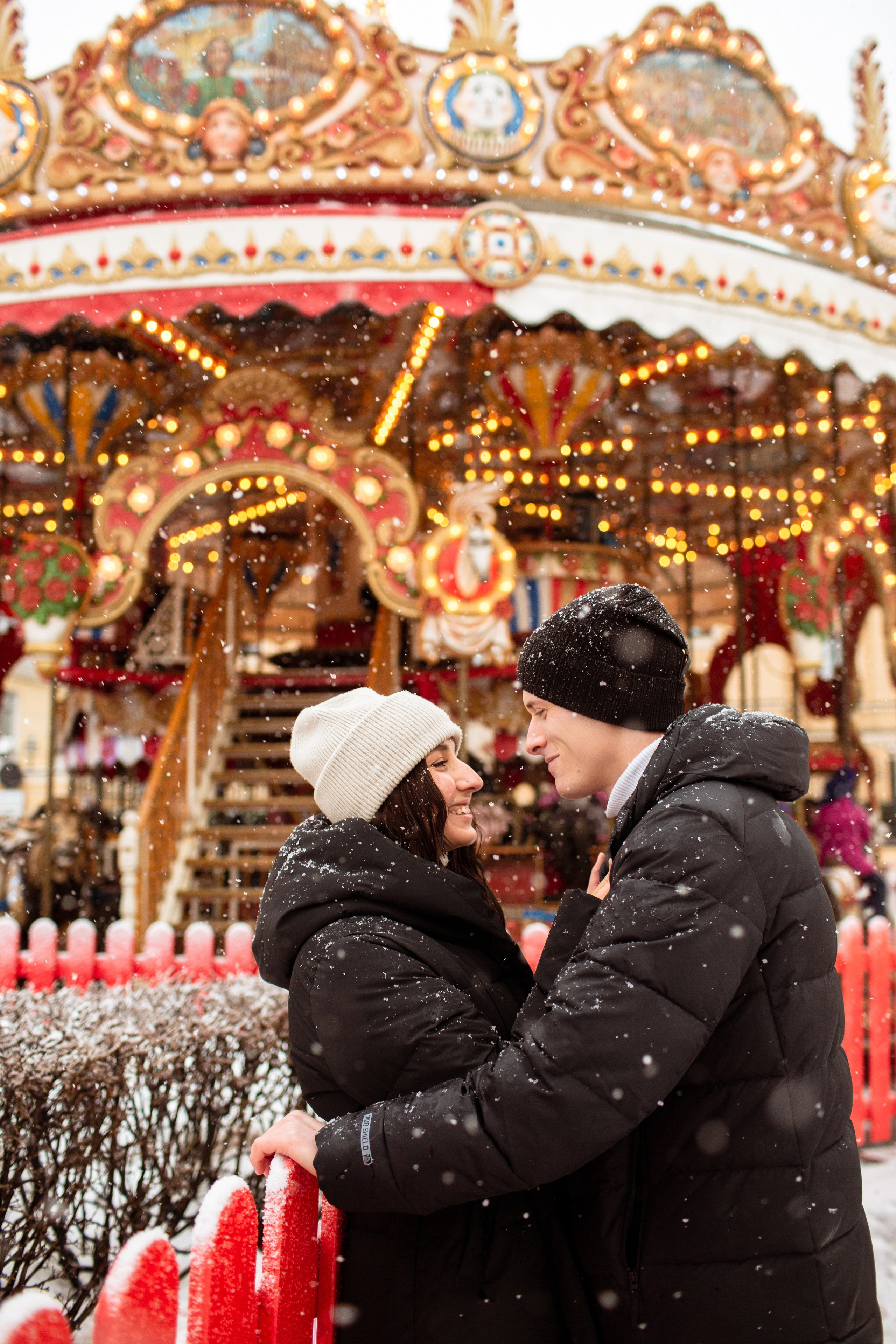 Фотопрогулка на Манежной площади Санкт-Петербурга: пара около рождественской карусели.