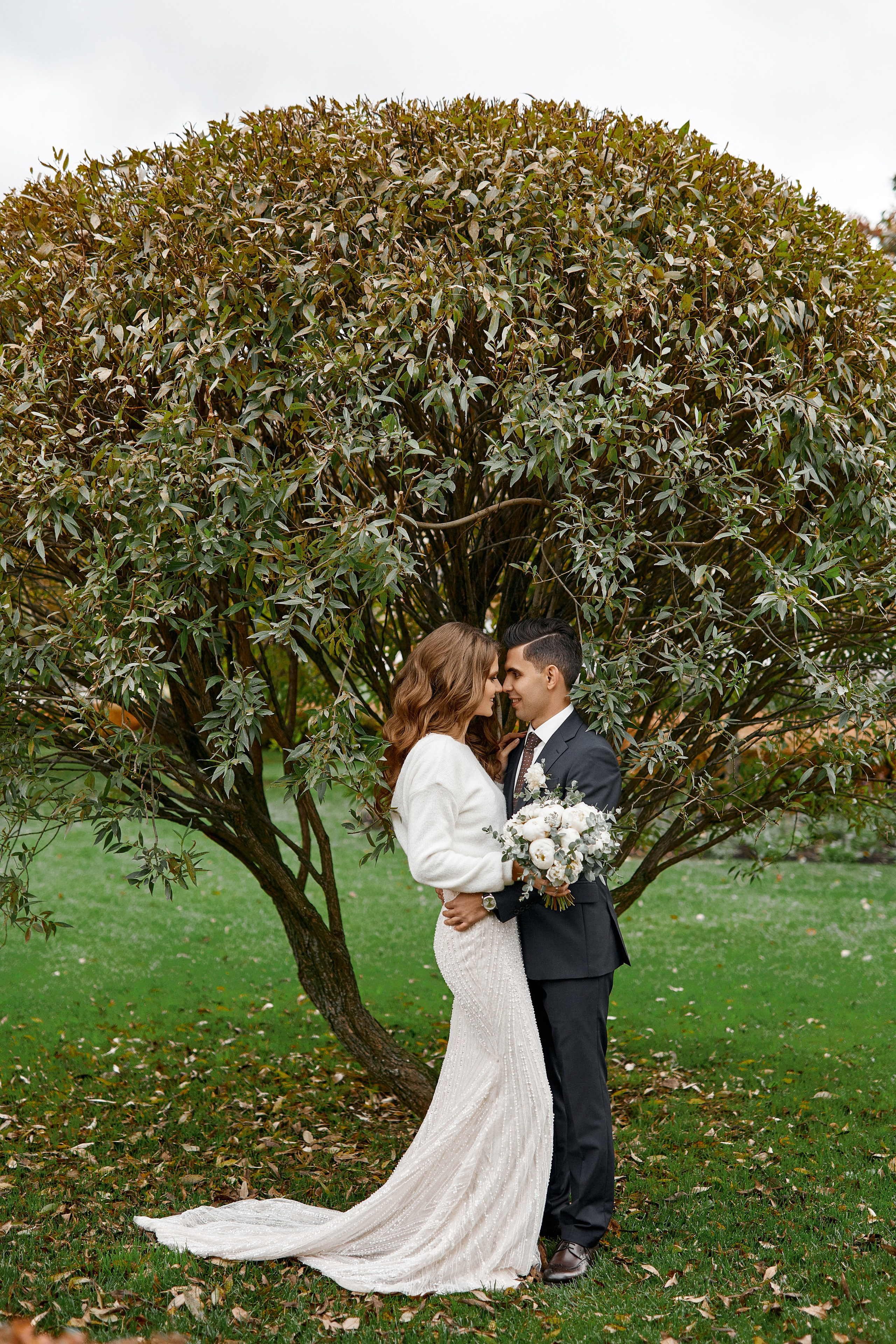 Свадебный фотограф проводит летнюю фотосессию в Москве для молодоженов в парке Культуры – фотография поженившейся пары на фоне красивого дерева