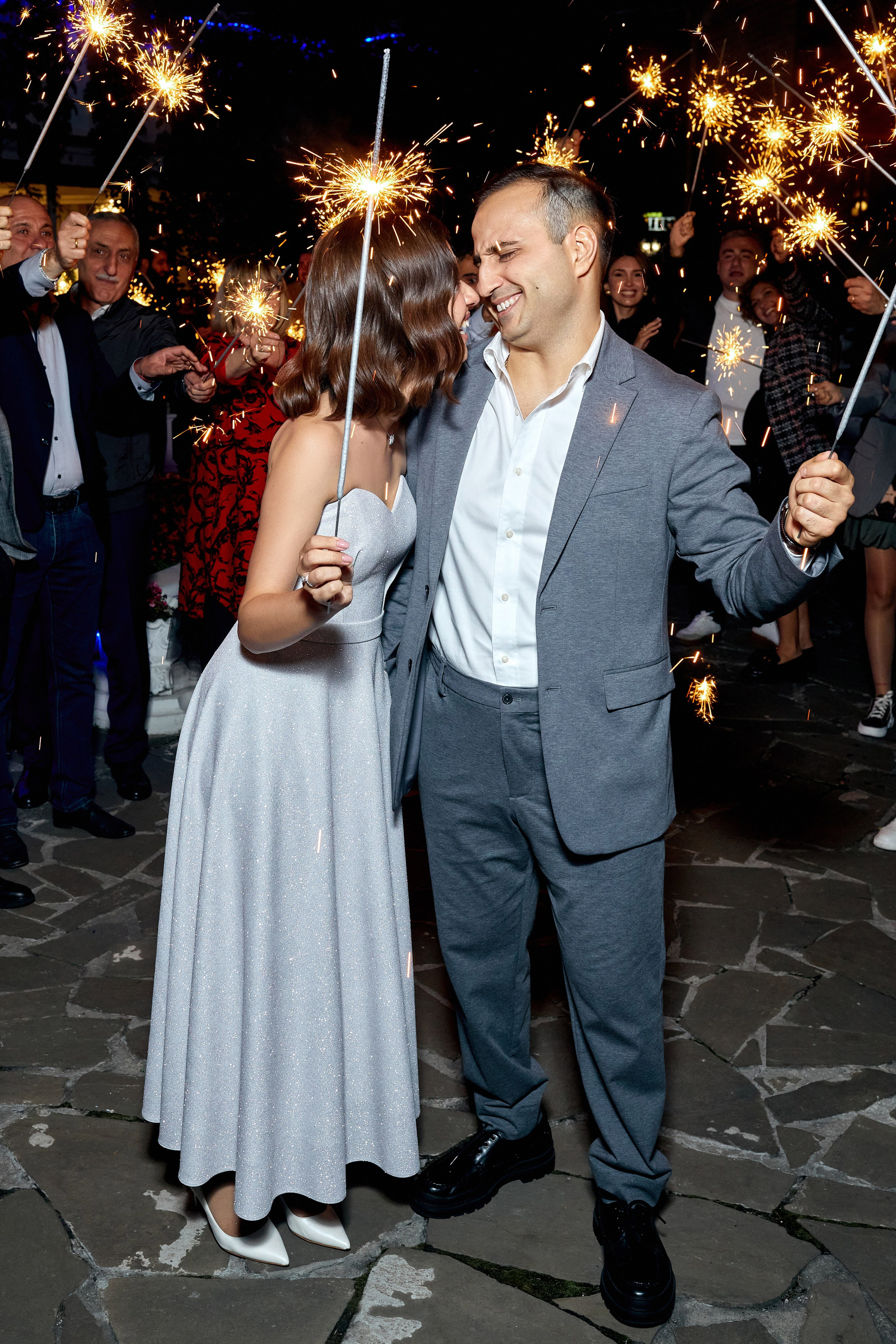 Профессиональный свадебный фотограф делает снимок молодоженов - фото с бенгальскими огнями