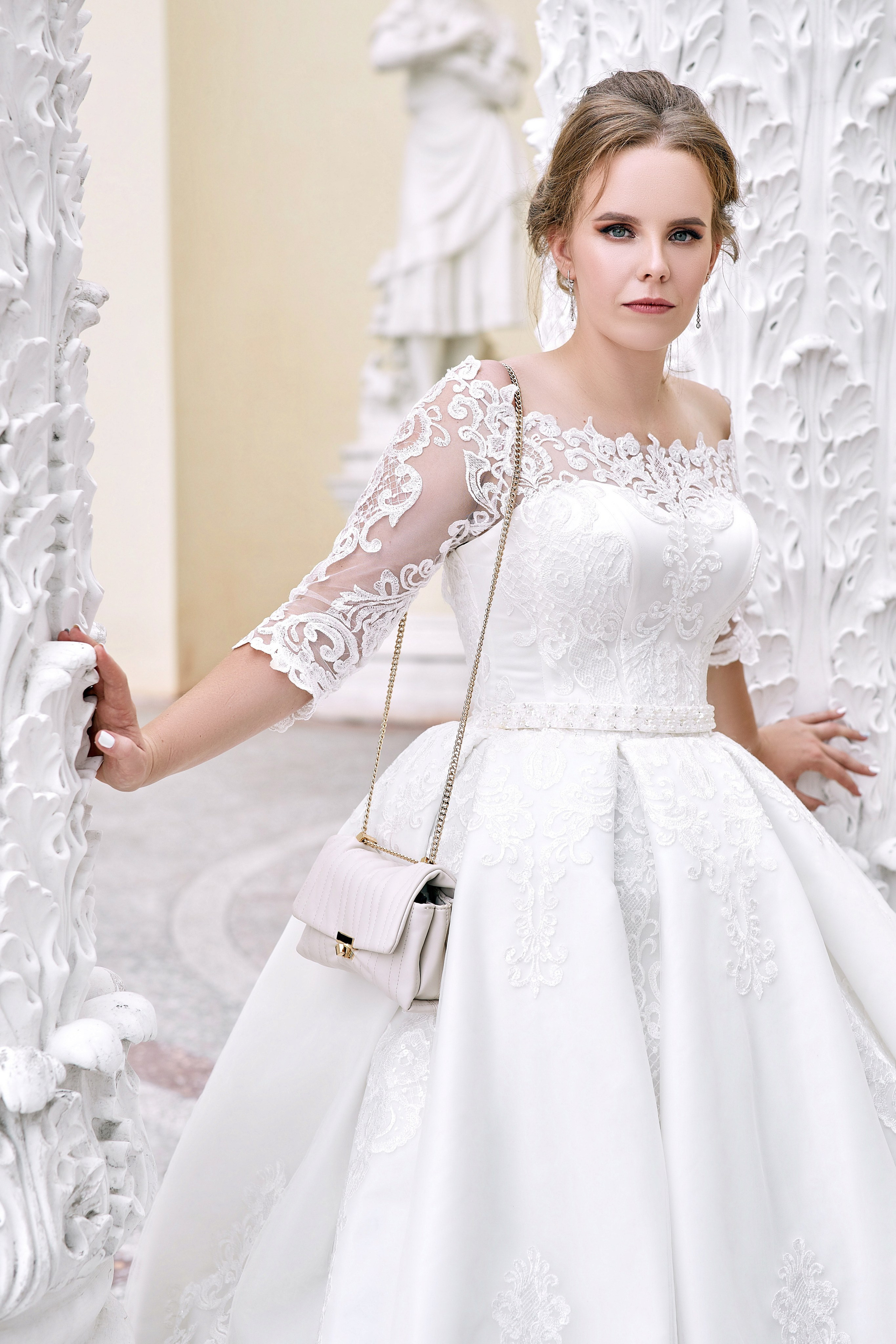 Фотограф в ЗАГС проводит фотосессию перед росписью на ВДНХ – фото невесты в красивом белом платье сидящих на фоне колонн