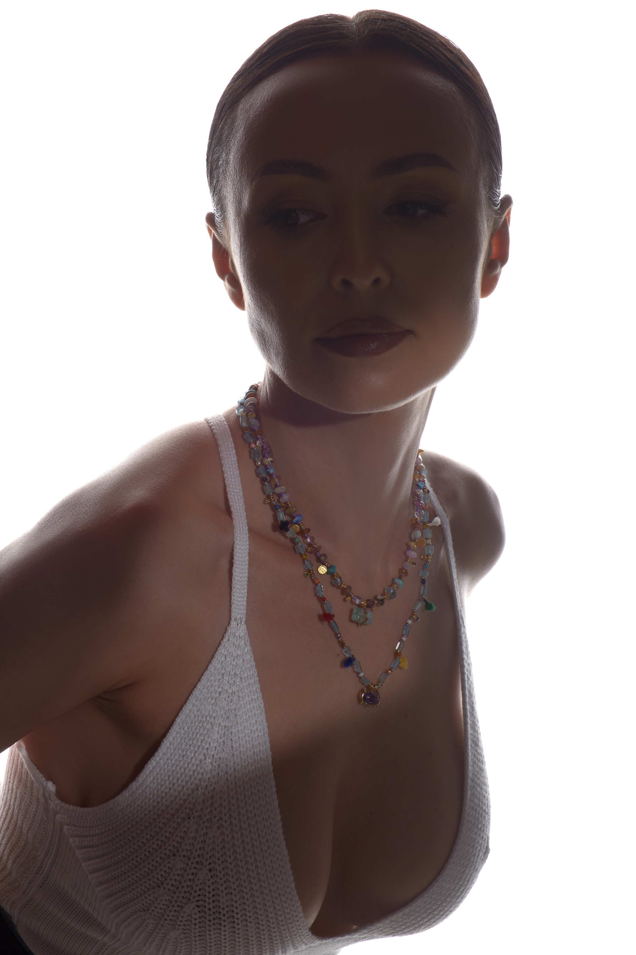 фэшн свет два источника в потолок за моделью для фотосессии украшений, женщина в вязаном топе без бюстгальтера, эротический портрет